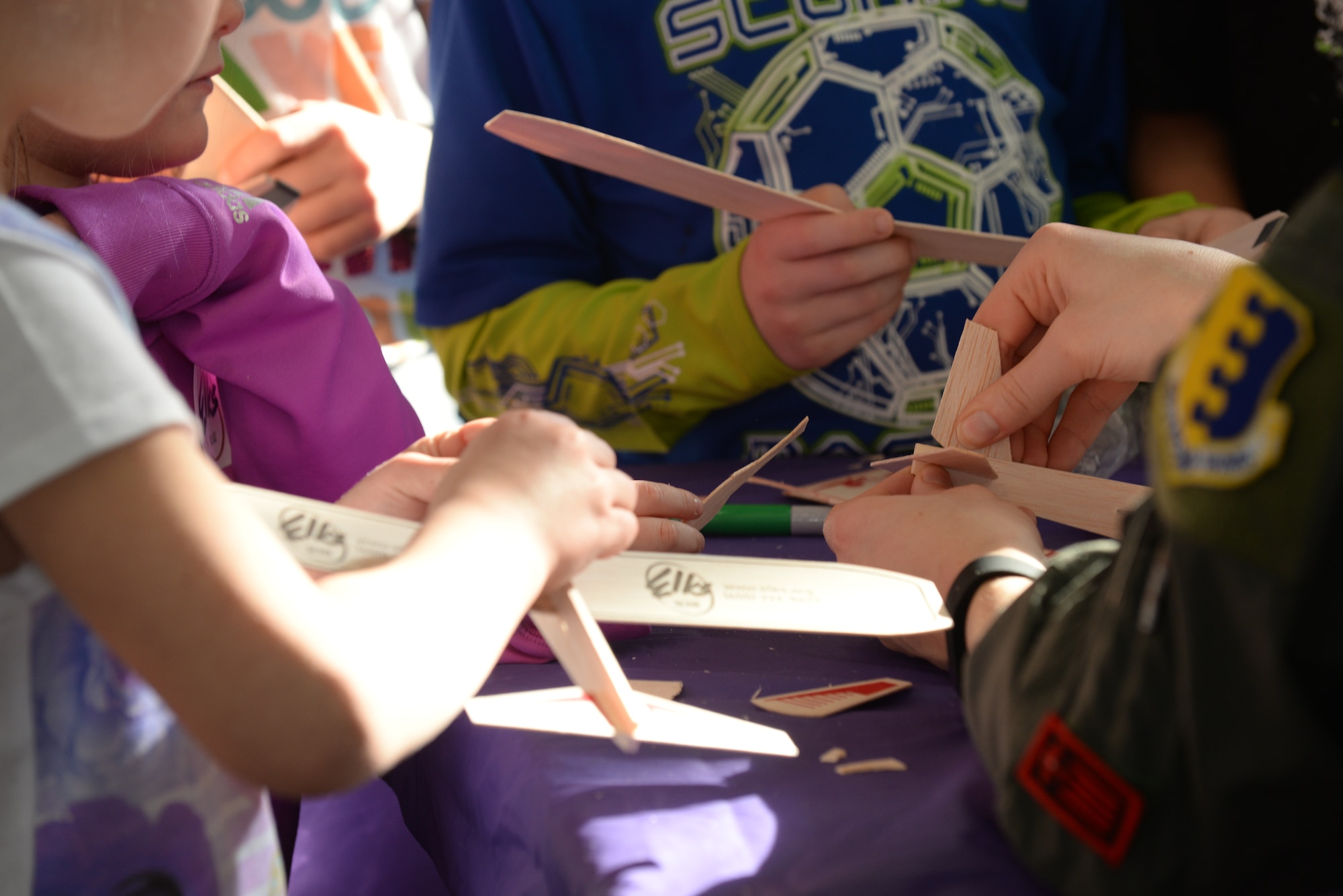 First Lt. Danielle Zidack, 34th Bomb Squadron weapon systems officer, teaches children how to build toy gliders during the 2016 Aviation Day at the Discovery Center in Pierre, S.D., Jan. 27, 2016. Throughout the event, children had the opportunity to build toy gliders while meeting with people from various aviation careers. (U.S. Air Force photo by Senior Airman Rebecca Imwalle/Released)