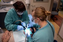 Jessica Arroyo (left), 22nd Aerospace Medicine Squadron dental assistant and Capt. Jenna Chase, 22nd AMDS general dentist, clean a patient’s teeth during a cavity-filling procedure, Jan. 27, 2016, at McConnell Air Force Base, Kan. The 22nd AMDS dentists and technicians provide a full range of dental services to include routine examinations, cleanings, general dentistry, periodontics, endodontics, and oral surgery. (U.S. Air Force photo/Senior Airman Colby L. Hardin)