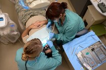 Capt. Jenna Chase (left), 22nd Aerospace Medicine Squadron general dentist, and Jessica Arroyo, 22nd AMDS dental assistant, remove cavities from a patient, Jan. 27, 2016, at McConnell Air Force Base, Kan. The 22nd AMDS dentists and technicians provide a full range of dental services to including examinations, cleanings, general dentistry, periodontics, endodontics, and oral surgery. (U.S. Air Force photo/Senior Airman Colby L. Hardin)