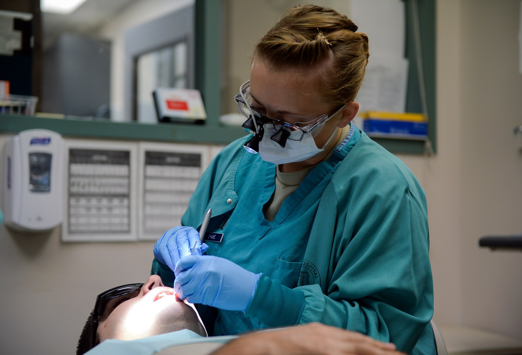 Capt. Jenna Chase, 22nd Aerospace Medicine Squadron general dentist, applies a bonding-agent to her patient, Jan. 27, 2016, at McConnell Air Force Base, Kan. Bonding-agent applicatinon is one of the steps to prepare for a cavity filling procedure. (U.S. Air Force photo Senior Airman Colby L. Hardin)