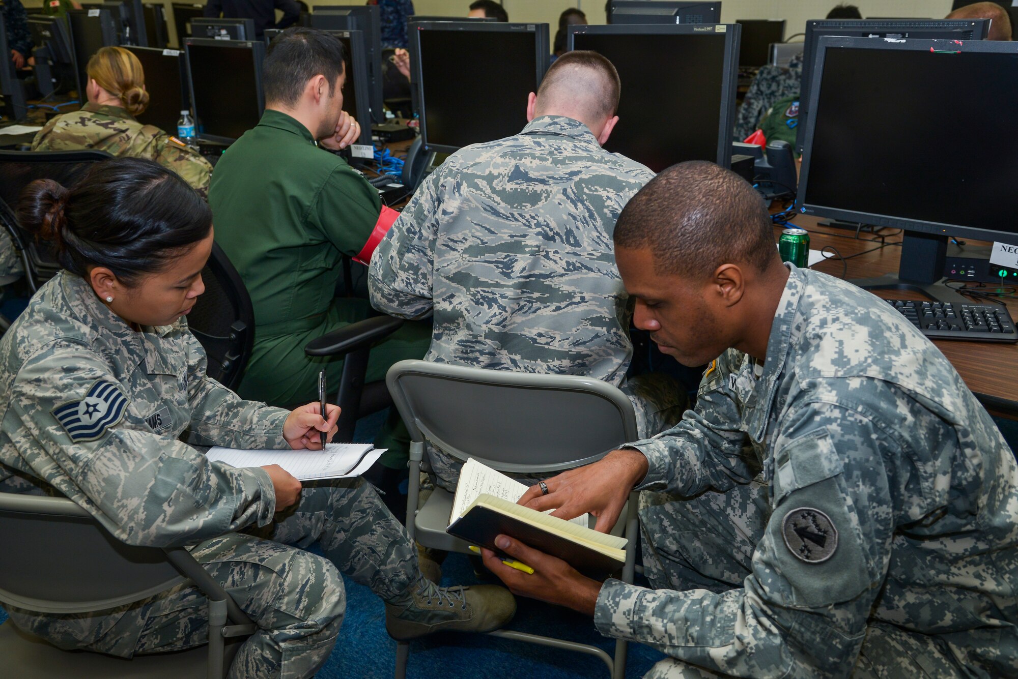 Members of the United States military exchange notes in a scenario during the Keen Edge 16 exercise at Yokota Air Base, Japan, Jan. 21, 2016. Keen Edge 16’s purpose is to facilitate the interactions and to improve interoperability with the Japan Self-Defense Force personnel during real-world contingencies. (U.S. Air Force photo by Senior Airman David Owsianka/Released)