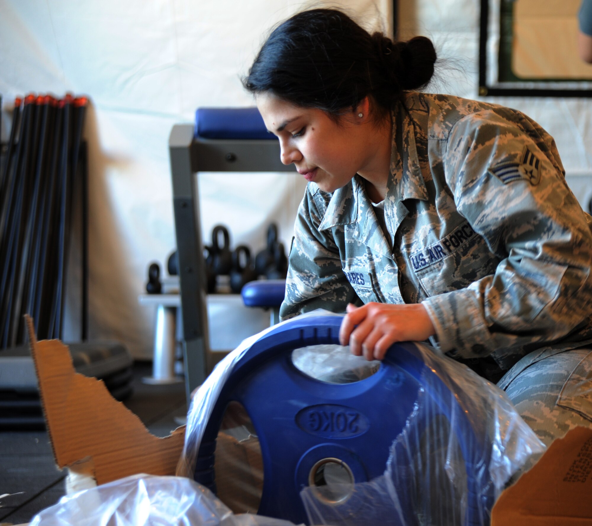 U.S. Air Force Senior Airman Cassandra Cazares, 39th Force Support Squadron fitness specialist, unwraps a weight for the new Patriot Village fitness facility Jan. 27, 2016 on Incirlik Air Base, Turkey. The facility allows deployed members to have a place to maintain fitness located near their living area. (U.S. Air Force photo by Airman 1st Class Daniel Lile/Released)