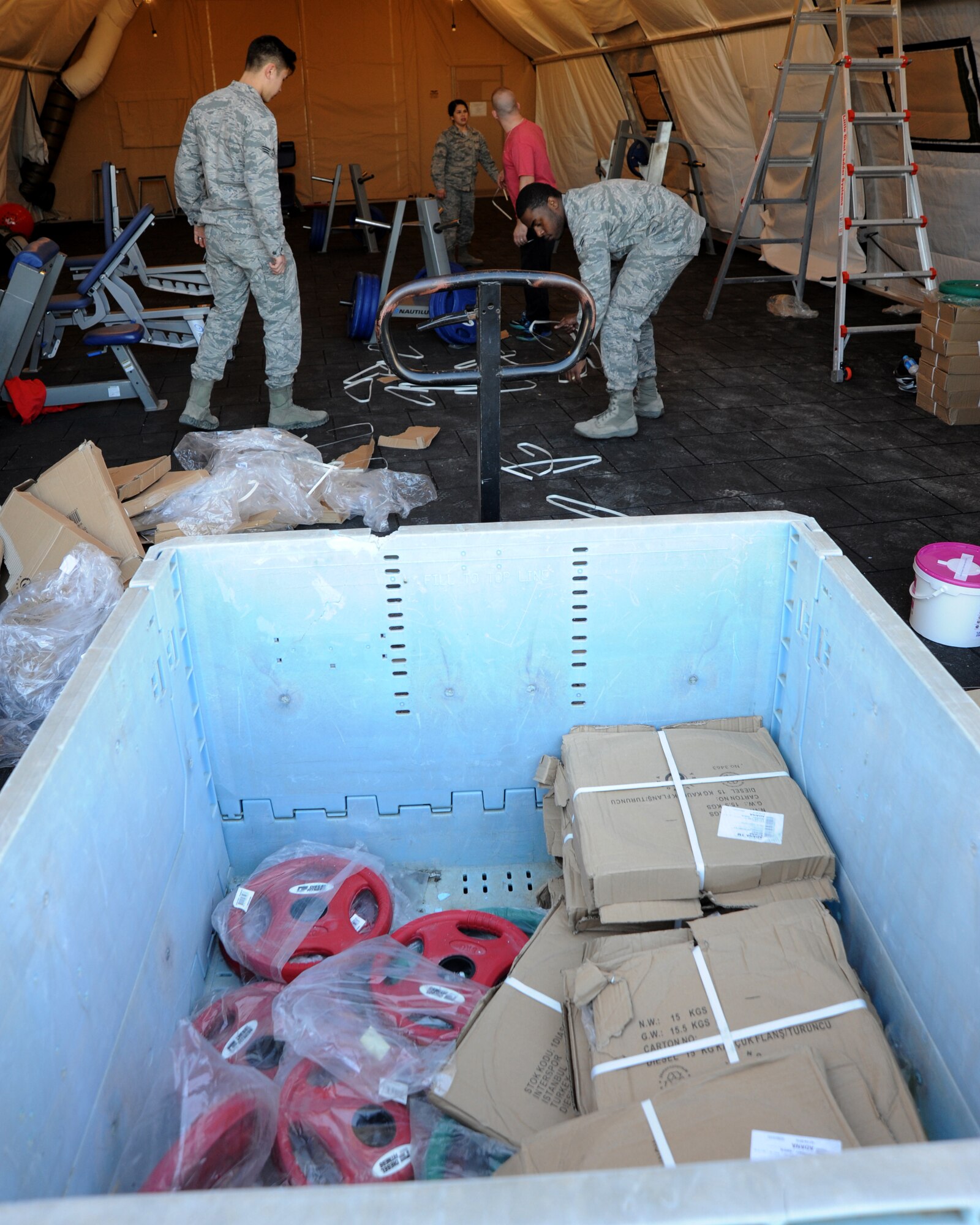 U.S. Airmen unload free weights from a cargo container inside of the new Patriot Village fitness facility Jan. 27, 2016, on Incirlik Air Base, Turkey. The facility is now functional and open 24 hours a day to deployed members on Incirlik AB. (U.S. Air Force photo by Airman 1st Class Daniel Lile/Released)