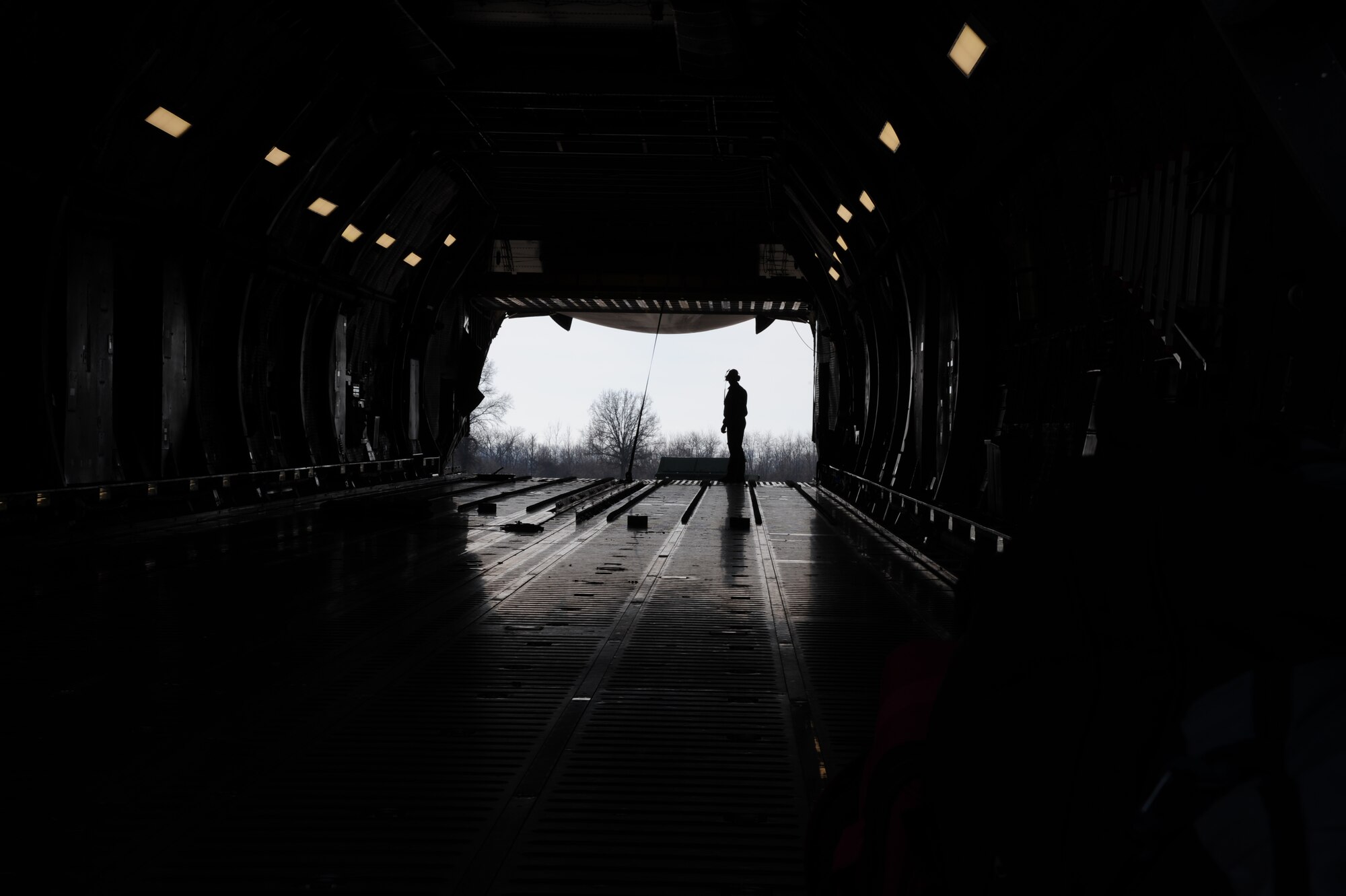 U.S. Air Force Staff Sgt. Conner Cooney, a 709th Airlift Control Squadron (ACS) loadmaster, oversees cargo upload operations at Whiteman Air Force Base, Mo., Jan. 25, 2016. Members of the 442d Maintenance Squadron and 709th ACS worked together to load cargo onto a C-5 for transport to Patrick AFB, Fla., as part of a combat, search and rescue exercise. (U.S. Air Force photo by Senior Airman Keenan Berry)