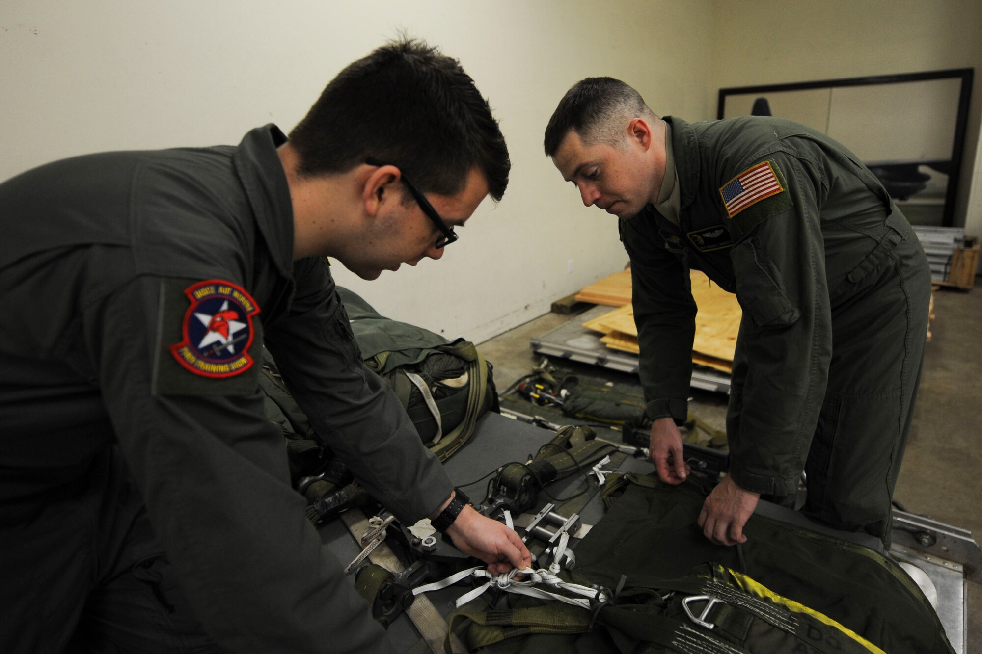 (From right) U.S. Air Force Staff Sgt. Michael Anderson, 48th Airlift Squadron non-commissioned officer in charge of information operations and C-130 formal training unit loadmaster instructor, teaches U.S. Air Force Airman 1st Class Garrett Cornett, a 714th Training Squadron loadmaster student, how to properly secure cargo Jan. 27, 2016, at Little Rock Air Force Base, Ark. While completing all the required training needed to instruct in the C-130J formal training unit, Anderson identified errors in asset accountability preparation for the upcoming unit evaluation inspection. (U.S. Air Force photo by Airman 1st Class Mercedes Taylor) 