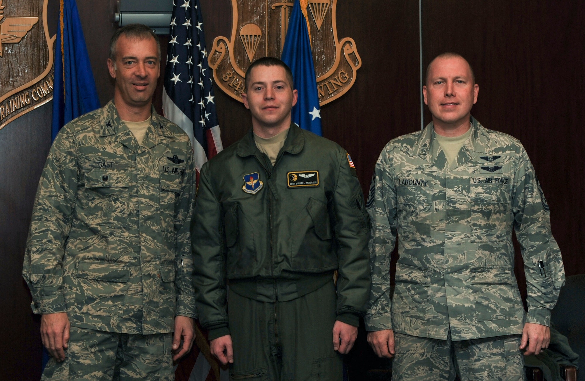 U.S. Air Force Col. Jeffrey Gast, 314th Airlift Wing vice commander, along with U.S. Air Force  Chief Master Sgt. Brian Labounty, 314th Airlift Wing command chief, congratulate U.S. Air Force Staff Sgt. Michael Anderson, 48th Airlift Squadron information operations noncommissioned officer C-130 formal training unit instructor loadmaster, on his selection as Combat Airlifter of the Week Jan. 27, 2016, at Little Rock Air Force Base, Ark. (U.S. Air Force photo by Airman 1st Class Mercedes Taylor)
