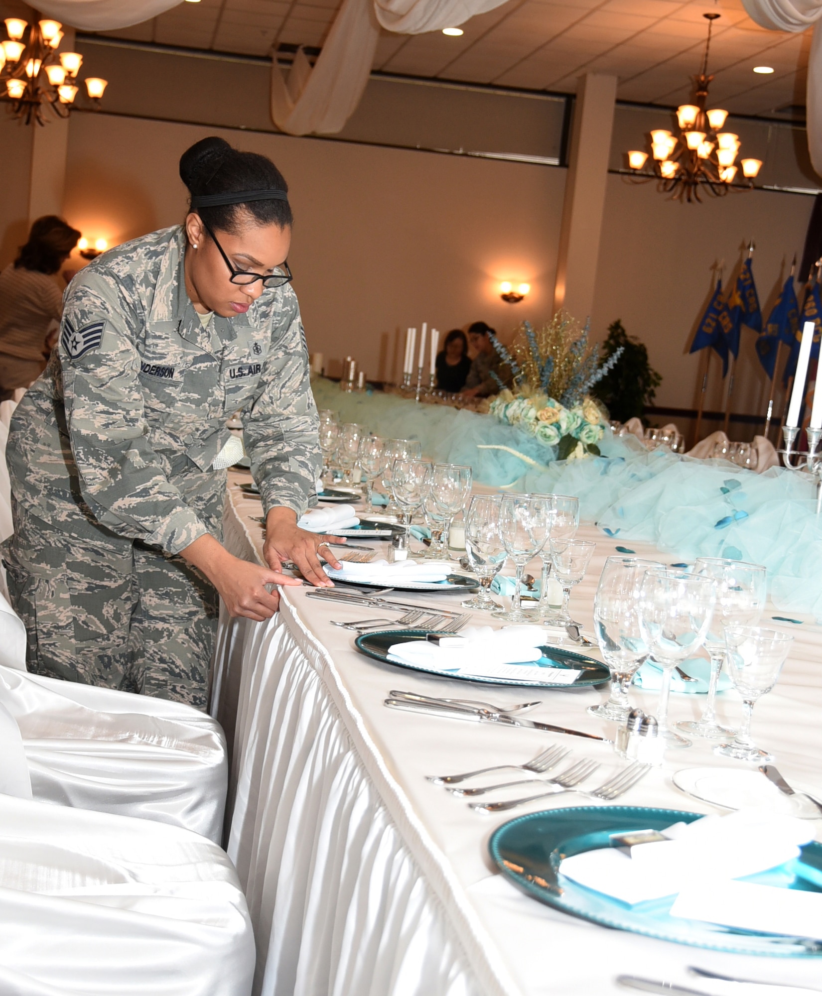160115-F-CK424-004 Staff Sgt. Octavia Henderson, with the 87th Dental Squadron, measures the placement of each table setting prior to a Heritage Dinner on Jan. 15, 2016, at Joint Base McGuire-Dix-Lakehurst, New Jersey. (U.S. Air Force photo/Tech. Sgt. Jamie Powell)
