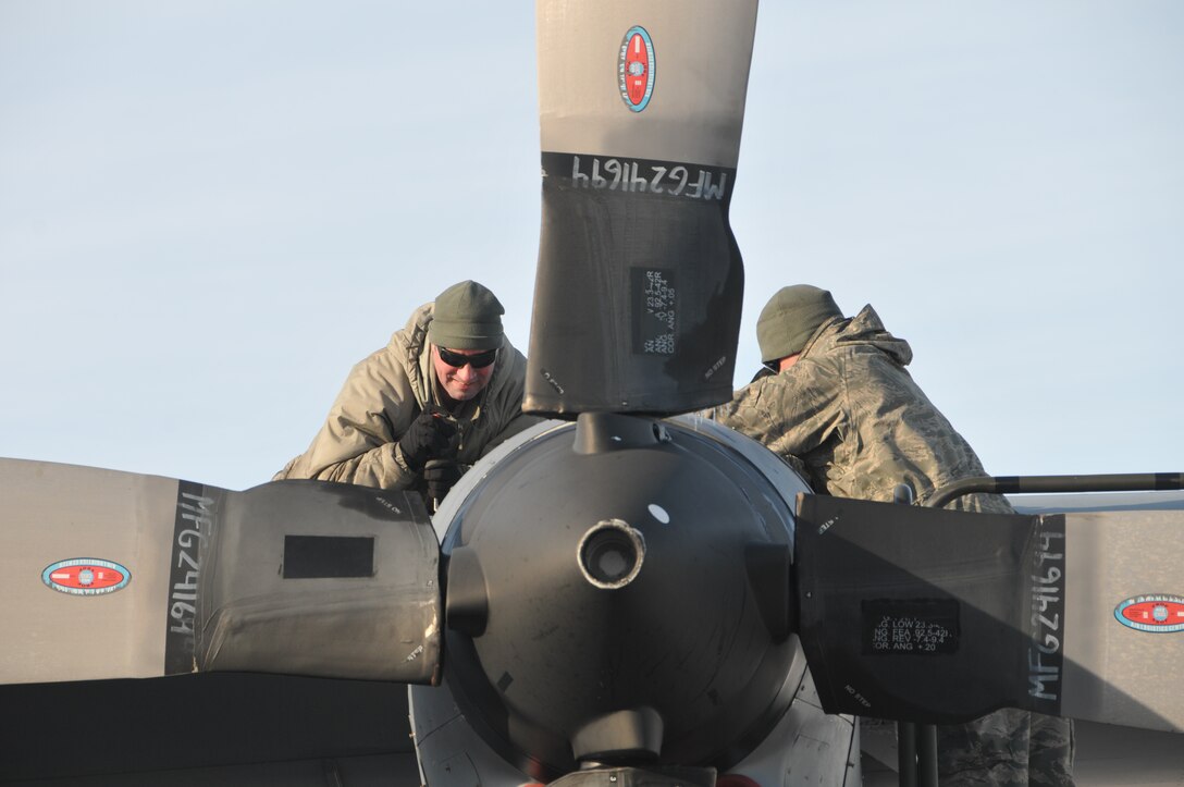 Staff Sgt. Jeff A. Hoock and Master Sgt. Tachie Navarro of the 120th Airlift Wing isochronal inspection dock perform a home station check (HSC) of the C-130 Hercules in the harsh Montana weather Jan. 6, 2016. A HSC is a medium range inspection due every nine months. (U.S. Air National Guard photo by Senior Master Sgt. Eric Peterson/Released)