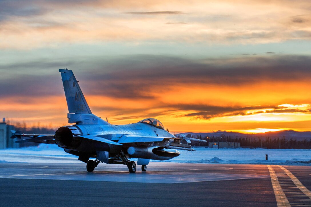 An Air Force F-16 Fighting Falcon aircraft prepares to take off shortly after sunrise from Eielson Air Force Base, Alaska, Jan. 24, 2016, to fly to Kadena Air Base, Japan, to participate in training exercises. The Falcon is assigned to the 18th Aggressor Squadron. Air Force photo by Staff Sgt. Shawn Nickel