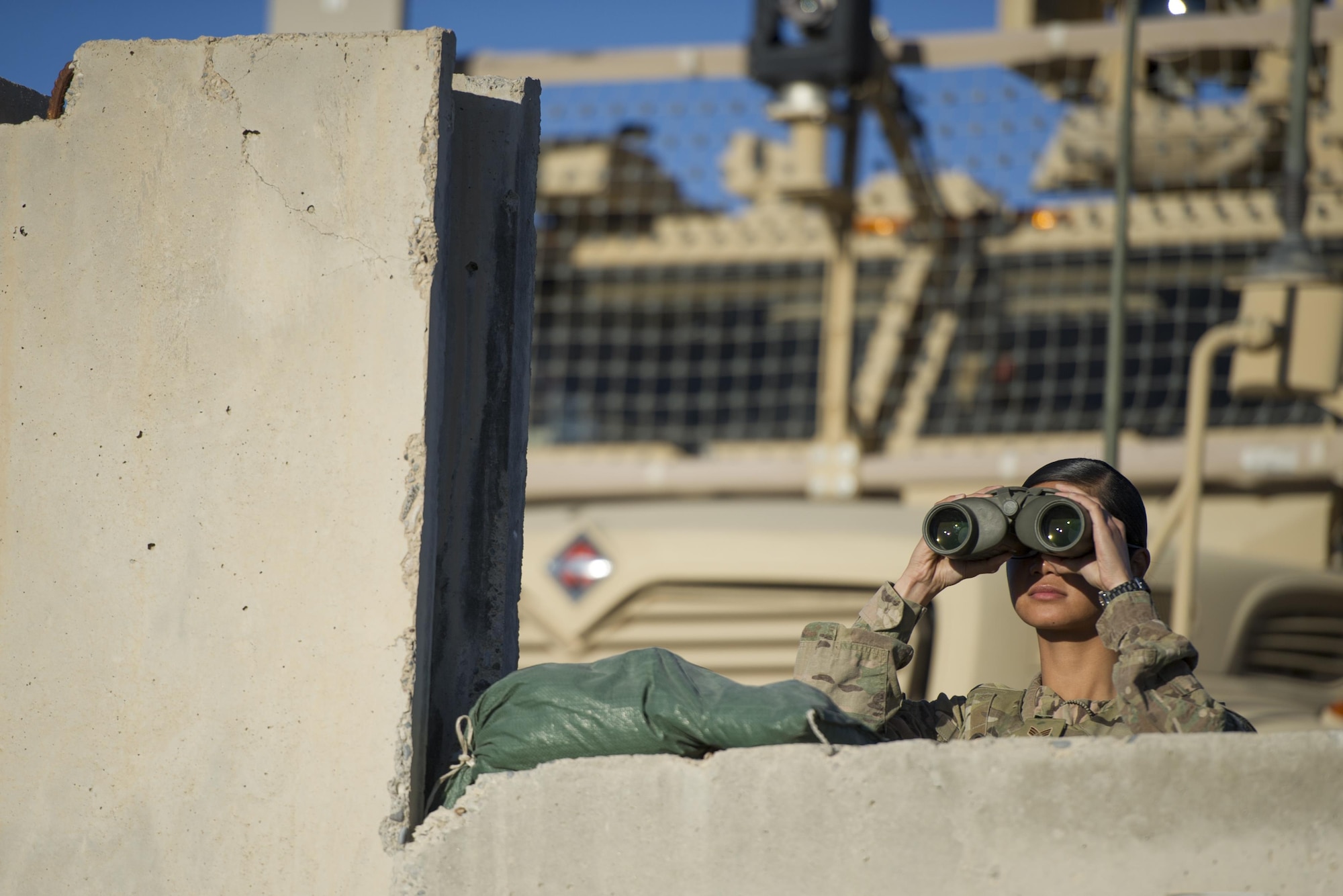 Senior Airman Winchell Austria, of the 451st Expeditionary Support Squadron’s Security Forces Flight, scans a sector with binoculars at Delta-1 Post on Kandahar Airfield, Afghanistan, Jan. 20, 2016. The post provides flightline security and overwatch for convoys returning from missions outside the wire in conjunction with security positions held by additional NATO forces. (U.S. Air Force photo/Tech. Sgt. Robert Cloys)