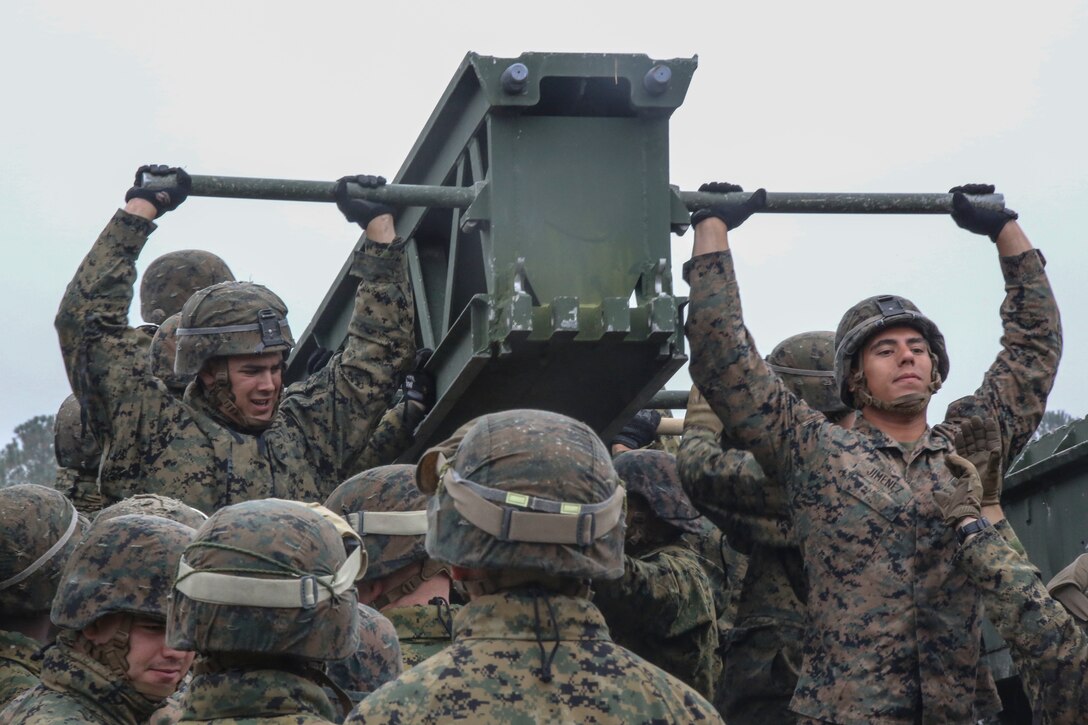 Marine students in the 8th Engineer Support Battalion Bridge Master’s Course lift a bridge bay during a field exercise at Camp Lejeune, N.C., Nov. 4, 2015. The course teaches Marines to lead the bridge building process, and is hosting Marines from 9th Engineer Support Battalion, 3rd Marine Logistics Group, based in Camp Hansen, Okinawa. Marines were required to work together to lift weight between 400 and 600 pounds. (U.S. Marine Corps photo by Cpl. Paul S. Martinez/Released)