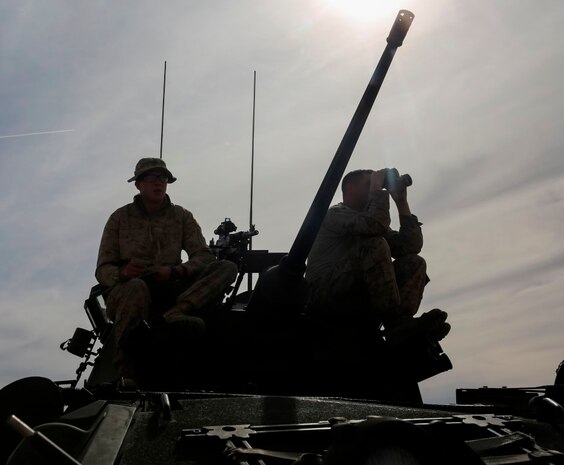 Two Marines scan the range during their live-fire gunnery qualification test at Marine Corps Air Ground Combat Center Twentynine Palms, Jan. 22, 2016. Live-fire tests like these allow the Marines of 1st Light Armored Reconnaissance Battalion, 1st Marine Division, I Marine Expeditionary Force to train for how they will execute their mission when they are deployed in real-world operations. (U.S. Marine Corps photo by Pvt. Robert Bliss)