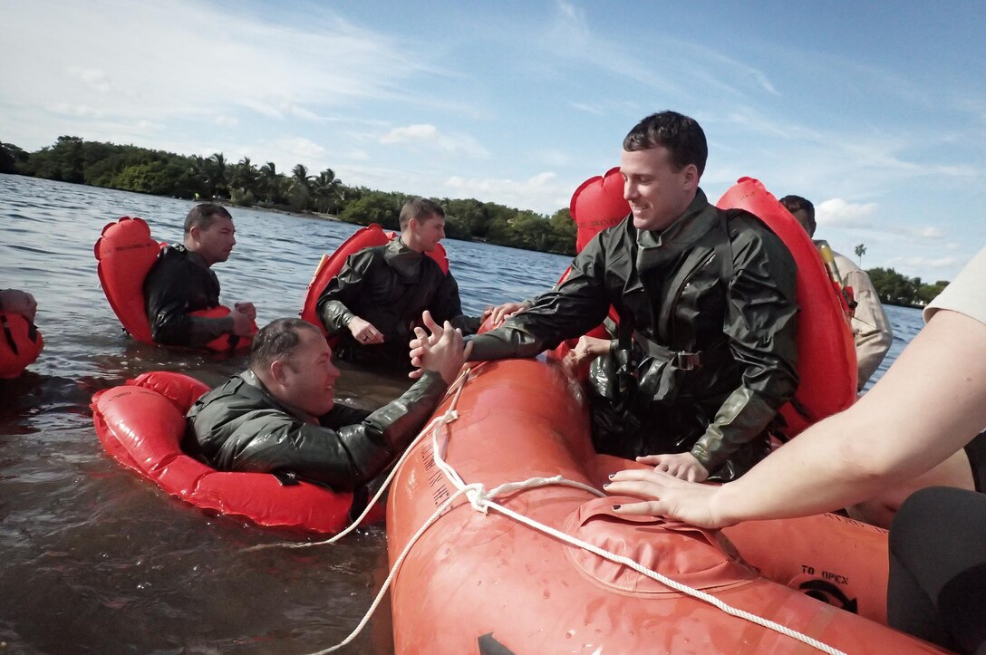 Air Force Maj. Dave Sumwalt, right, helps pulls Air Force Capt. Lonnie Mazuranich into a raft during water survival training near Homestead Air Reserve Base, Fla., Jan. 20, 2016. Sumwalt and Mazuranich are pilots assigned to the 101st Rescue Squadron. New York Air National Guard photo by Staff Sgt. Christopher S. Muncy