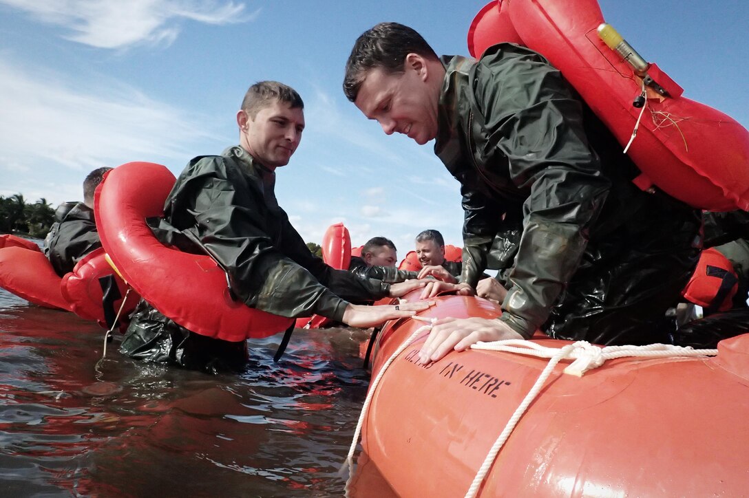 Air Force Maj. Dave Sumwalt, right, settles into a raft during water survival training near Homestead Air Reserve Base, Fla., Jan. 20, 2016. Sumwalt is a pilot assigned to the 101st Rescue Squadron. New York Air National Guard photo by Staff Sgt. Christopher S. Muncy
