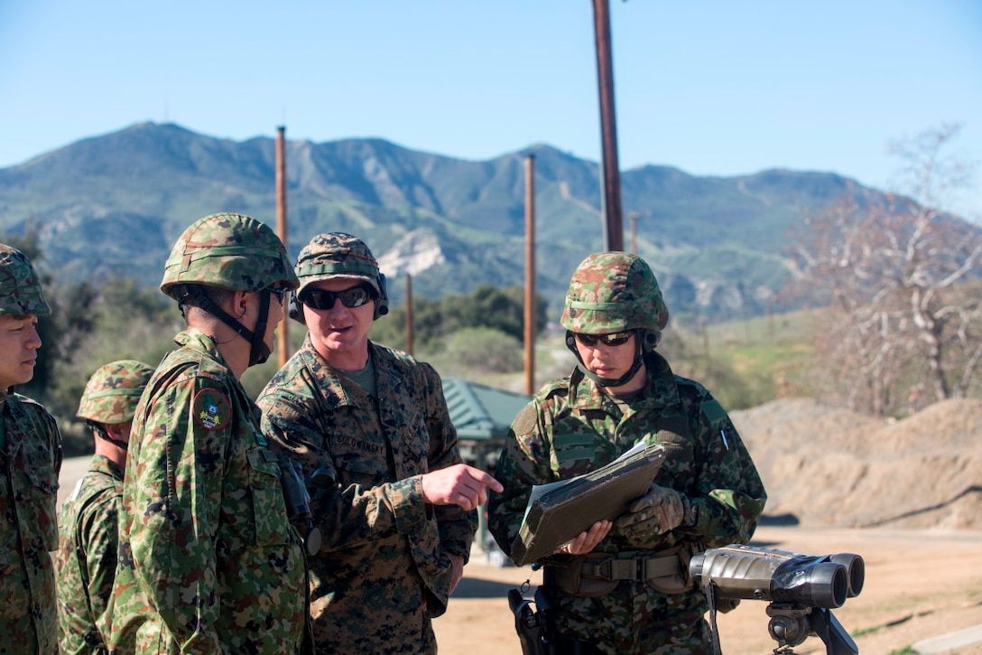 U.S. Marine Staff Sgt. Matthew Solowynsky (Center,) chief instructor with 1st Marine Division School’s Pre-Scout Sniper Course, explains the target layout of an unknown distance range, to Japan Ground Self-Defense Force Col. Yoshiyuki Goto (left), Western Army Infantry Regiment commander, aboard Marine Corps Base Camp Pendleton, Calif., Jan 28, 2016. As one of several training evolutions during Exercise Iron Fist, U.S. Marines, and JGSDF marksmen shared their skills and techniques to bolster one another’s fighting capabilities.
