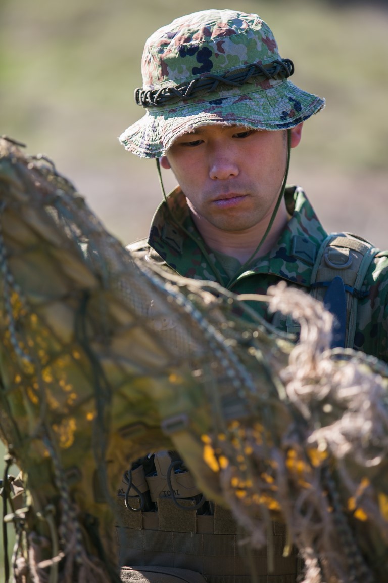 A soldier with the Japan Ground Self-Defense Force (JGSDF) examines a piece of cloth for a ghillie suit during hide site construction training at Exercise Iron Fist 2016 aboard Camp Pendleton, Calif., Jan. 28, 2016.  Ghillie suits camouflage troops using foliage from the surrounding area during clandestine missions. (U.S. Marine Corps photo by Cpl. Xzavior T. McNeal/Released)