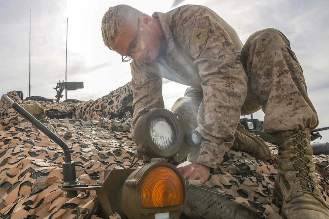 Marine Corps Pfc. Merrick Martius maintains the infrared light on an armored vehicle during a live-fire gunnery qualification test on Marine Corps Air Ground Combat Center, Twentynine Palms, Calif., Jan. 22, 2016. Martius is an armored vehicle crewman assigned to the 1st Marine Division's Headquarters and Service Company, 1st Marine Expeditionary Force. Marine Corps photo by Pvt. Robert Bliss