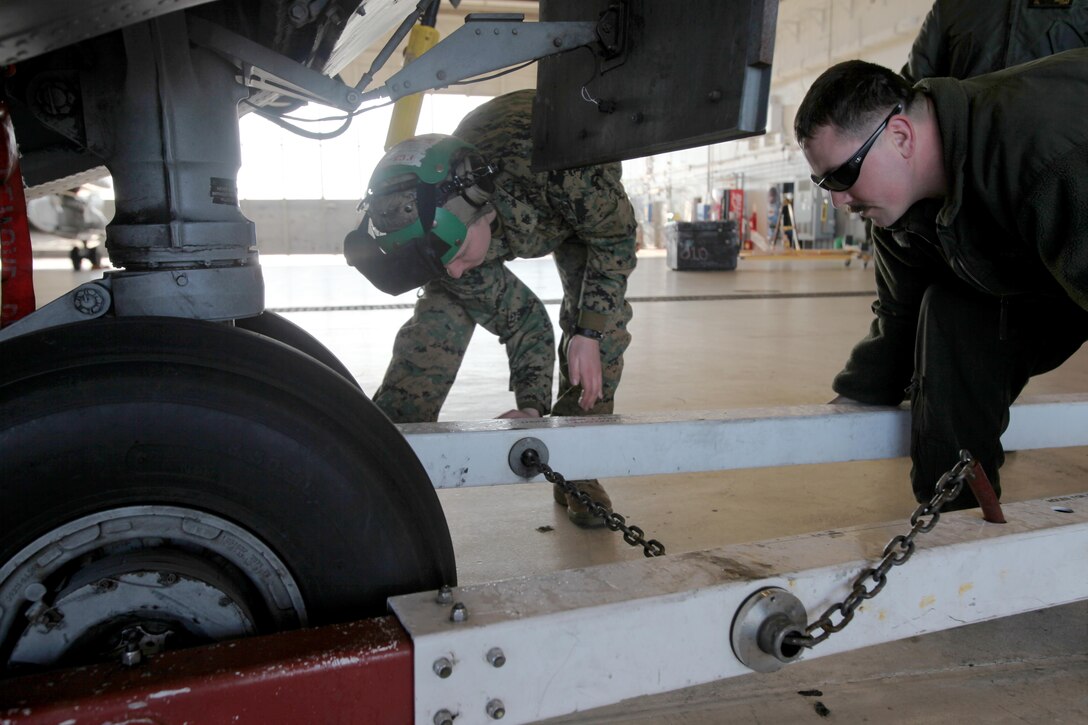 Cpl. Aliza Berkheimer and Sgt. Robert D. Lyvers hook a tow bar to the landing gear of a CH-53E Super Stallion during aircraft transportation at Marine Corps Air Station Cherry Point, N.C., Jan. 29, 2016. 63 Marines from Marine Heavy Helicopter Squadron 464 broke down CH-53E Super Stallions and AH-1W Super Cobras for transport to Norway for Exercise Cold Response 2016. Berkheimer is an avionics technician and Lyvers is a flight line crew chief, both with HMH-464. (U.S. Marine Corps photo by Cpl. Jason Jimenez/Released)