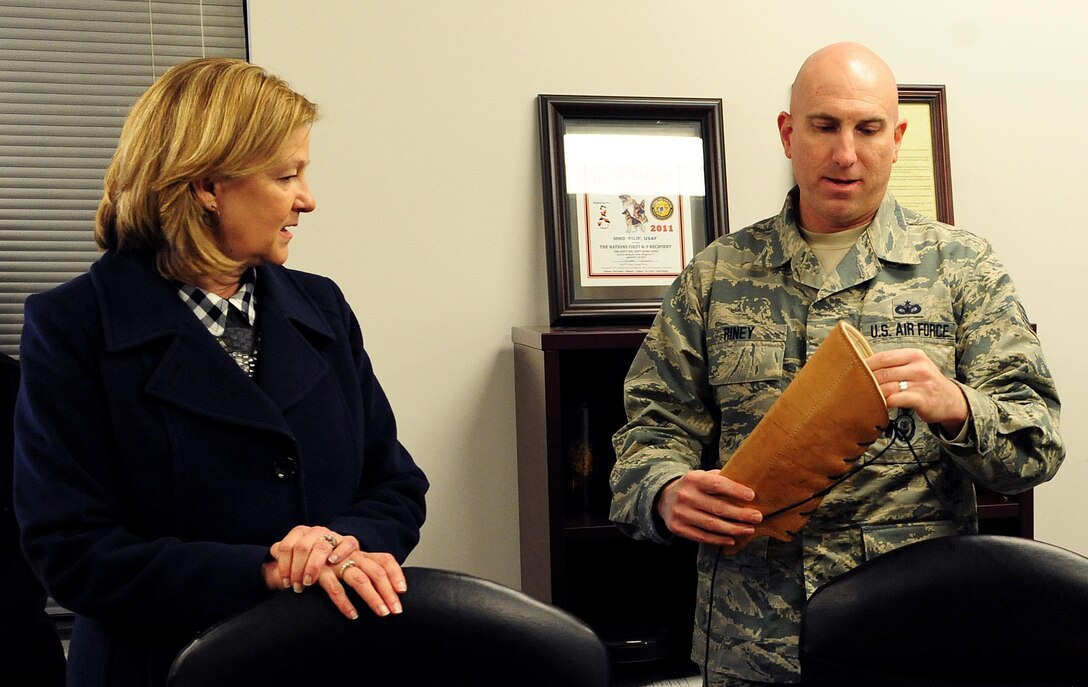 Tech. Sgt. William Riney, 509th Security Forces Squadron kennel master, shows Kim Rand, wife of AFGSC commander Gen. Robin Rand, different protection gear available to military working dog handlers for training during her visit to Whiteman Air Force Base, Mo., Jan. 20, 2016. After Rand’s tour of the kennels, the handlers performed a series of training exercises while explaining situations in which they would be used. (U.S. Air Force photo by Airman 1st Class Jazmin Smith)