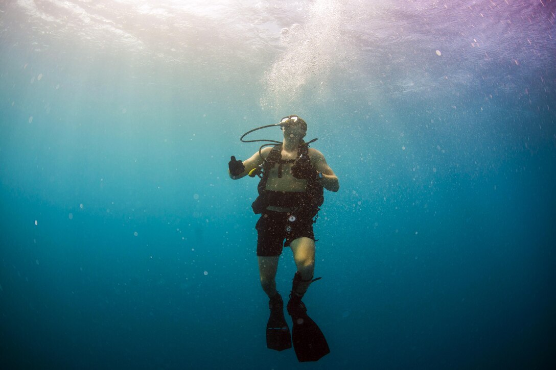 Navy Petty Officer 2nd Class Chris Keiper swims to the surface during a diving operation off the coast of Santa Rita, Guam, Jan. 27, 2016. Navy photo by Petty Officer 2nd Class Daniel Rolston