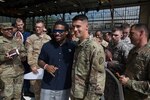Pfc. Scott Wilder, an attack helicopter repairer, 2-6 Cavalry Regiment  takes a photo with NFL Running Back DeAngelo Williams at the 2016 Pro Bowl Draft party Jan. 27 at Wheeler Army Airfield, Hawaii. (