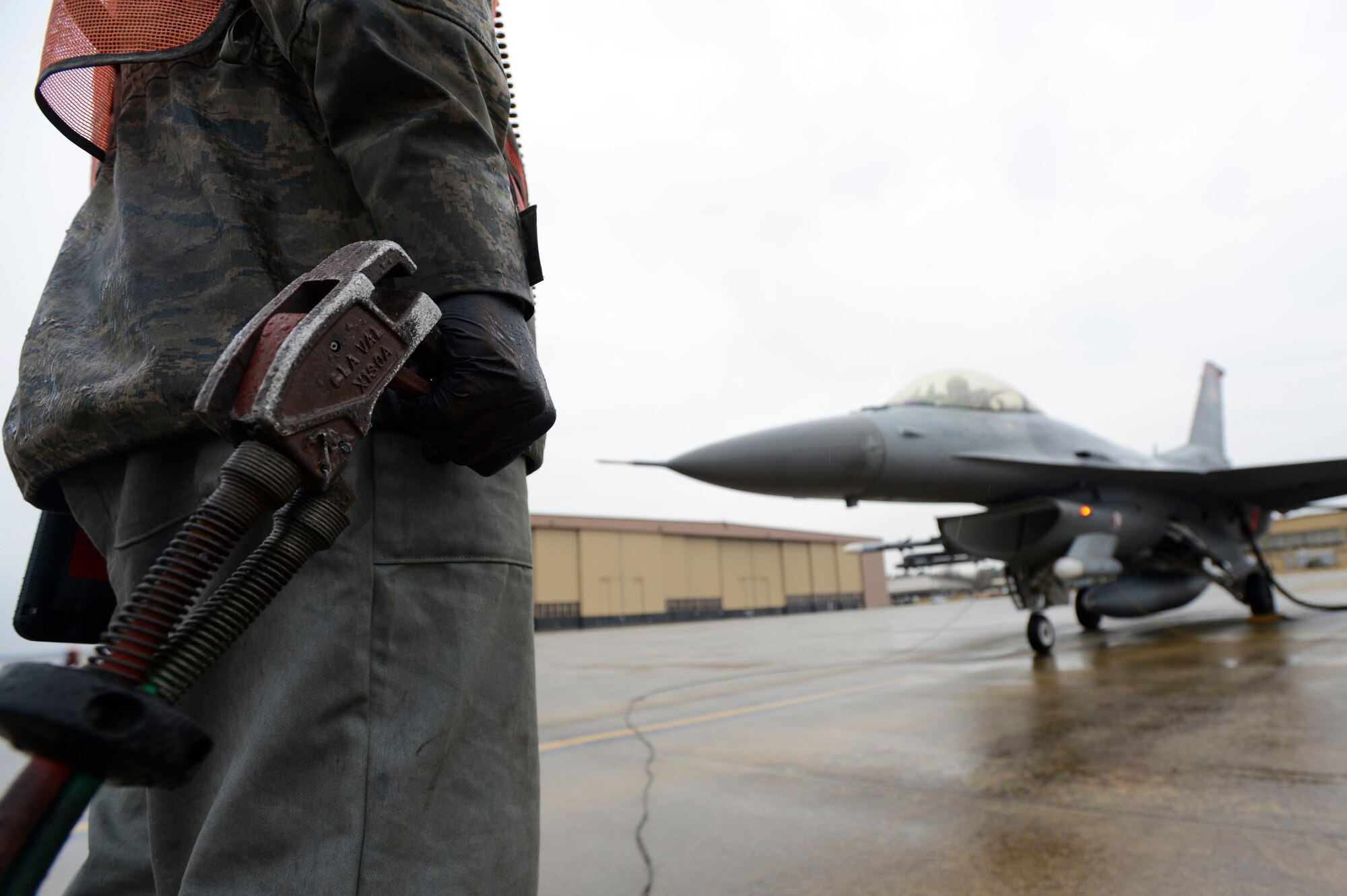 A U.S. Airman holds a fuel trigger while hot-pit refueling an F-16CM Fighting Falcon at Shaw Air Force Base, S.C., Jan. 28, 2016. Throughout the combat refueling method known as hot pits, approximately 1,200 gallons of jet fuel is transferred into the aircraft. (U.S. Air Force photo by Senior Airman Jensen Stidham/Released) 