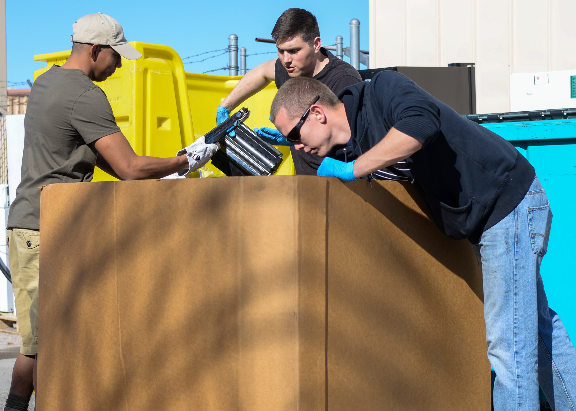 Airman 1st Class Raul Perales (left), 823rd Maintenance Squadron HH-60 crew chief, Airman 1st Class Jeremiah Reynolds (center), 823rd MXS maintainer and Airman 1st Class Douglas Wheeler (right),  823rd MXS HH-60 crew chief, sort through items at the Recycling Center  at Nellis Air Force Base, Nev., Jan.26, 2016. Members from the 823rd MXS took time out of their day to volunteer at the Recycling Center. (U.S. Air Force photo by Airman 1st Class Kevin Tanenbaum)