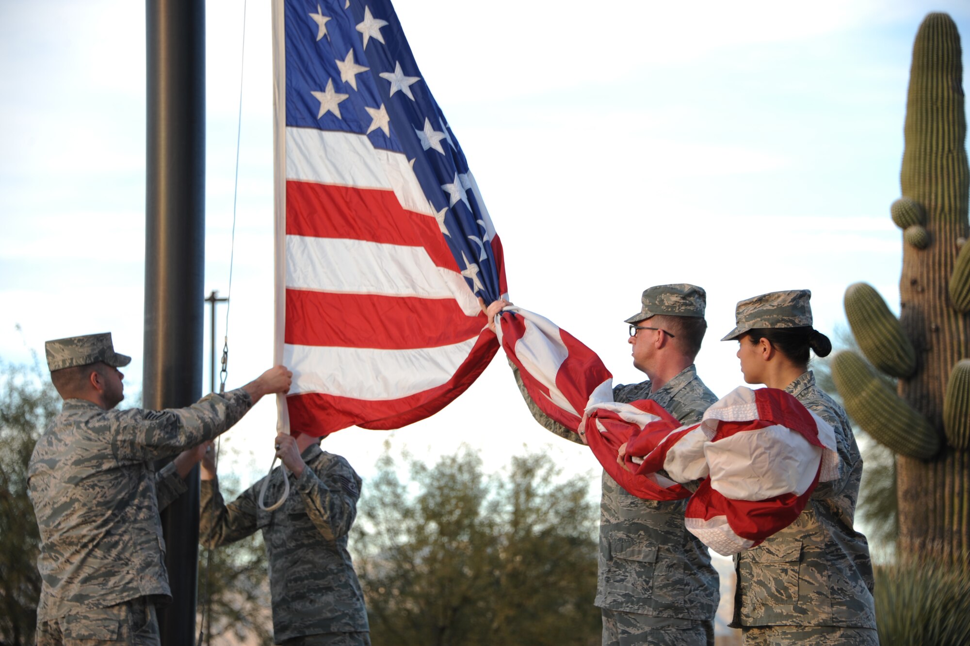 U.S. Airmen from the 355th Fighter Wing catch the American flag during a retreat ceremony at Davis-Monthan Air Force Base, Ariz., Jan. 28, 2016. The American flag flying outside the 355th Fighter Wing building was taken down ceremoniously and handed off to the McCulloch-Wagner American Legion Post 109 to be retired. (U.S. Air Force photo by Airman Basic Nathan H. Barbour/Released)