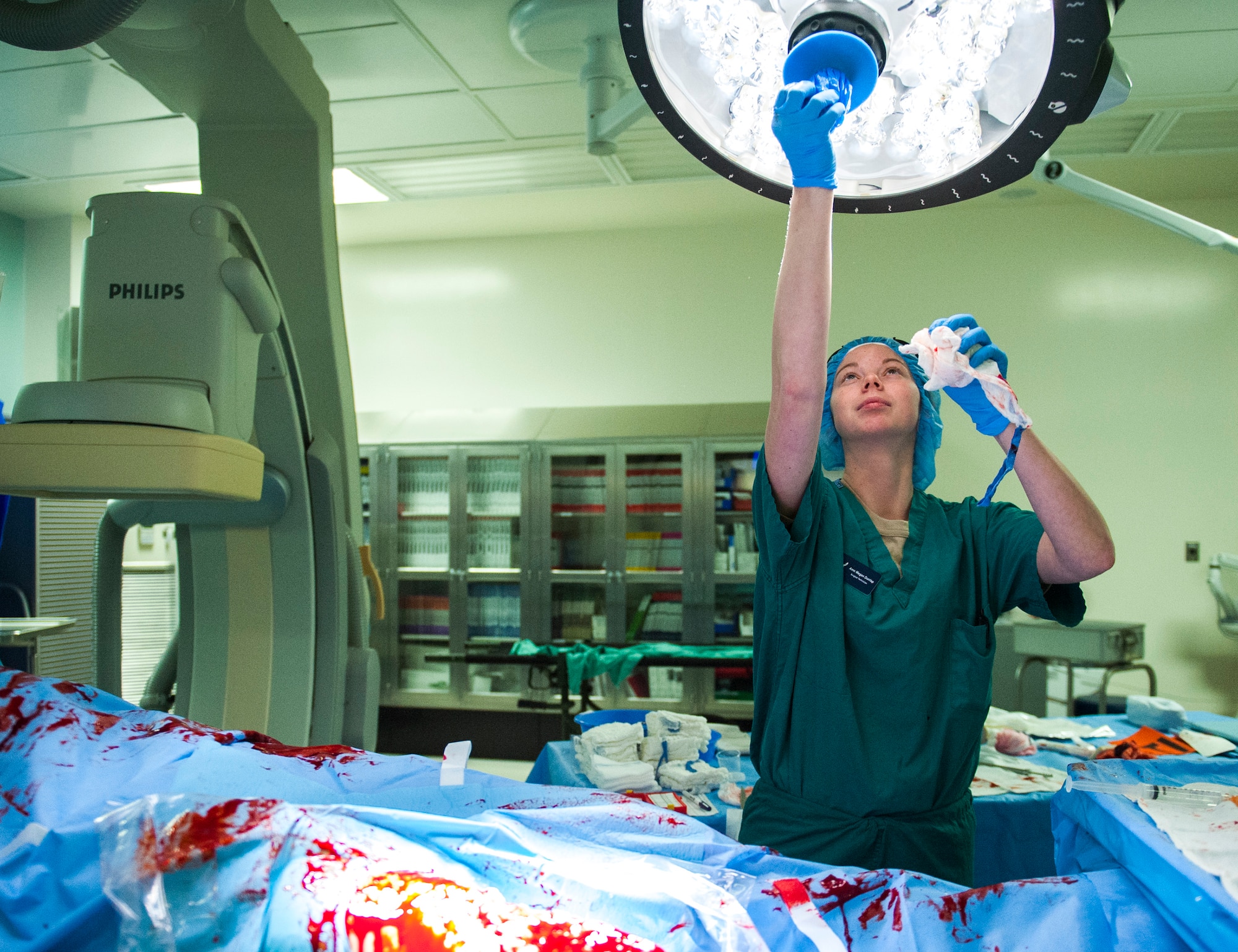 Airman Megan Dunlap, a surgical technician with the 96th Surgical Operations Squadron, removes the sterile covers from an operating room lamp after an exercise of a simulated amputation Jan. 14 at Eglin Air Force Base, Fla.  The 96th MDG surgical teams’ exercises simulate traumatic injuries commonly seen during deployments. The teamwork skills honed during exercises are also applied daily in the hospital’s operating rooms. (U.S. Force/Ilka Cole) 