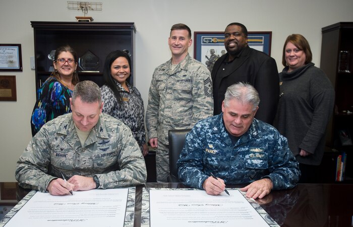 Col. Robert Lyman, Joint Base Charleston commander, and Capt. Timothy Sparks, JB Charleston deputy commander, both sign their Military Saves Campaign cards Jan. 25, 2016, at the headquarters building on Joint Base Charleston – Air Base, S.C. Military Saves is a campaign that helps servicemembers and their families save money and reduce debt. (U.S. Air Force photo/Senior Airman Clayton Cupit)