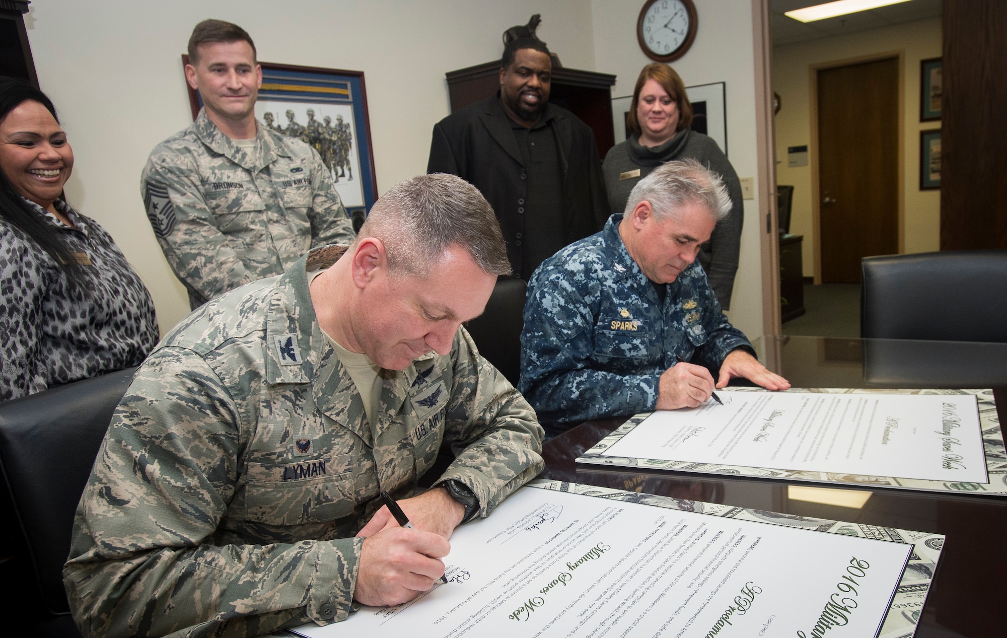 Col. Robert Lyman, Joint Base Charleston commander, and Capt. Timothy Sparks, JB Charleston deputy commander, both sign their Military Saves Campaign cards Jan. 25, 2016, at the headquarters building on Joint Base Charleston – Air Base, S.C. Military Saves is a campaign that helps servicemembers and their families save money and reduce debt. (U.S. Air Force photo/Senior Airman Clayton Cupit)