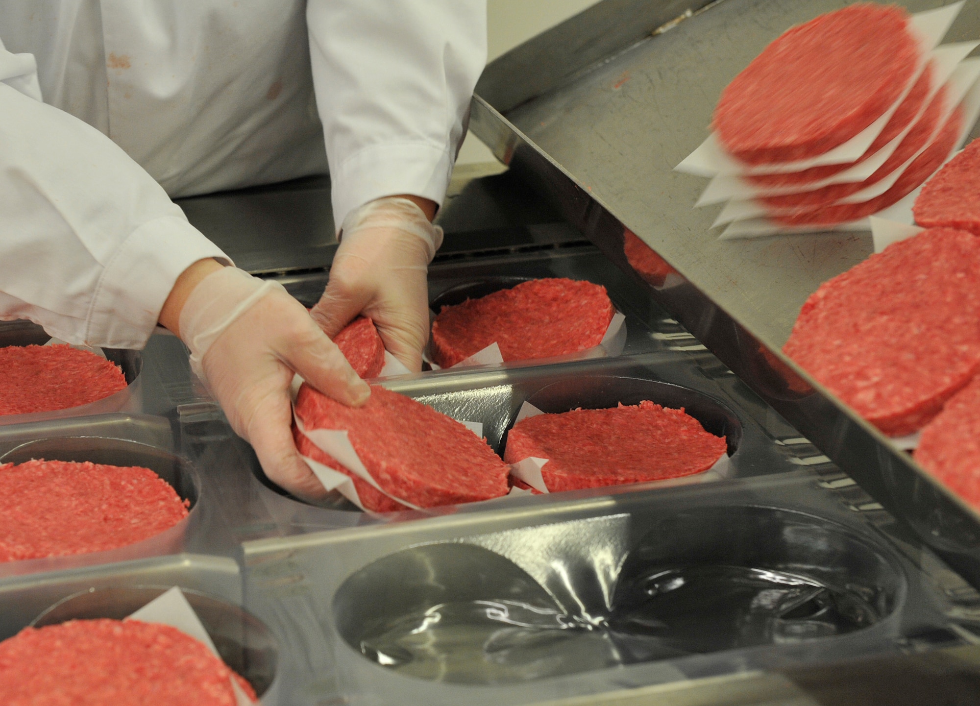 An employee hand packages hamburger patties at the Ramstein Central Meat Processing Plant Jan. 25, 2016, at Ramstein Air Base, Germany. The Ramstein CMPP cuts, packages and ships more than 713,000 pounds of fresh and frozen beef and pork to 35 commissaries and 18 Army and Air Force Exchange Service locations overseas. (U.S. Air Force photo/Airman 1st Class Larissa Greatwood)