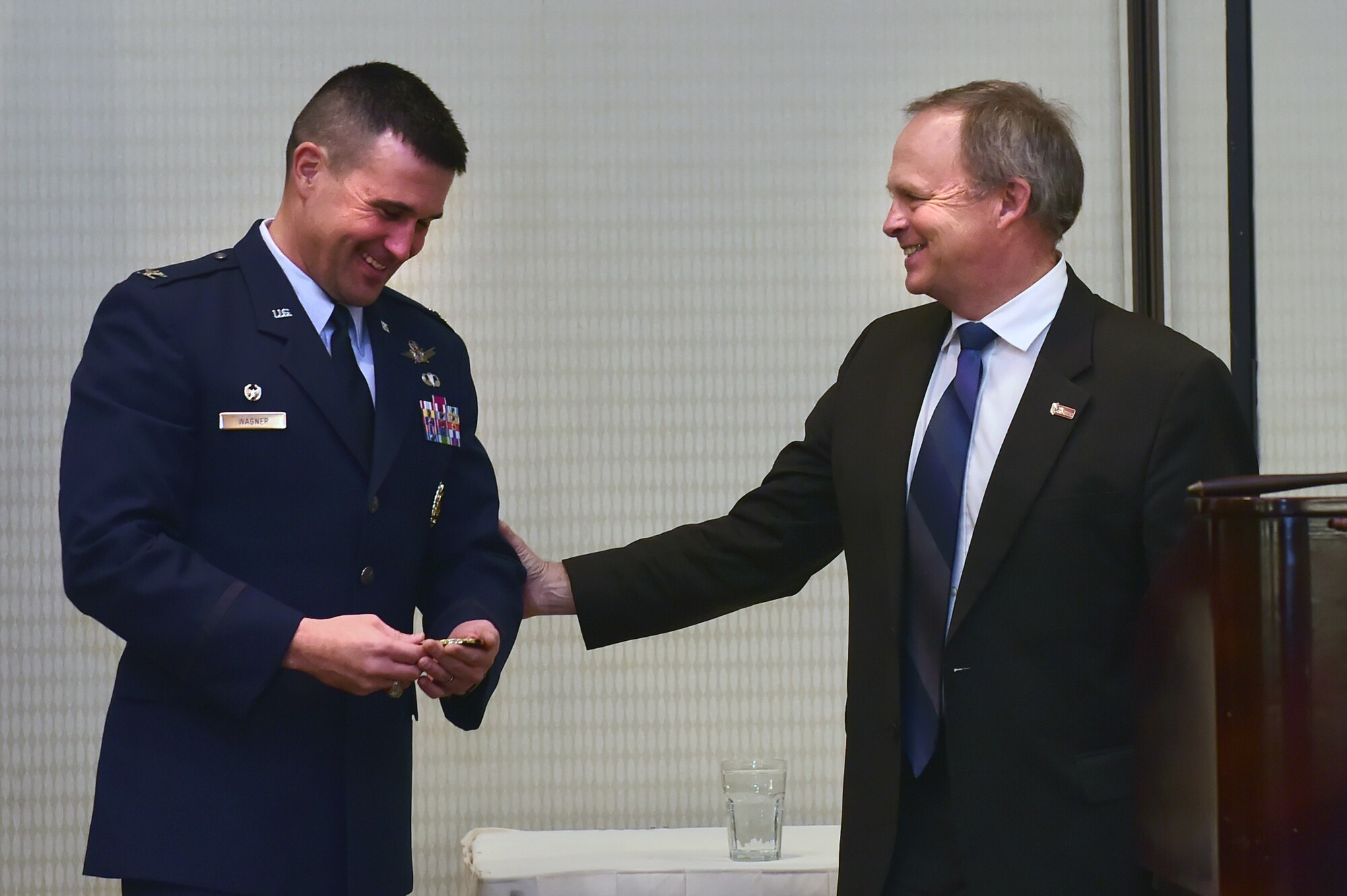 Col. John Wagner, 460th Space Wing commander, receives a coin from Kevin Hougen, Aurora Chamber of Commerce president, during the State of the Base luncheon Jan. 29, 2015, at the DoubleTree by Hilton in Aurora, Colo. The luncheon gives Buckley Air Force Base leaders the opportunity to connect with community leaders, giving them information on upcoming projects and the base’s economic impact. (U.S. Air Force photo by Airman 1st Class Luke W. Nowakowski/Released)