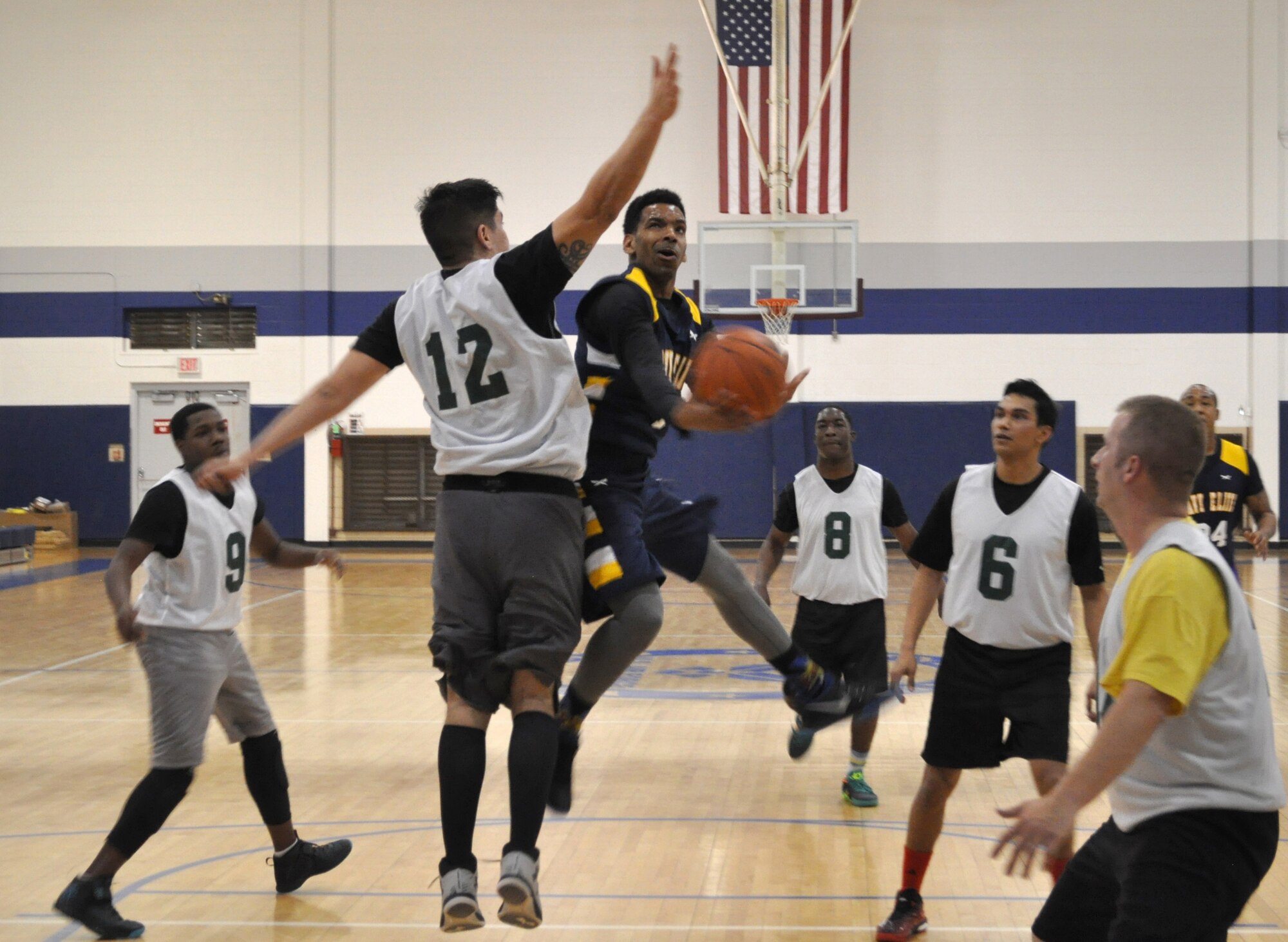 SCW-1’s Kione Morgan prepares a shot in the Jan. 19 game against 72 OSS at the Gerrity Fitness Center. 72 OSS’s Salvador Canales, No. 12, is defending. Navy won 40-26. (Air Force photo by John Parker/Released)