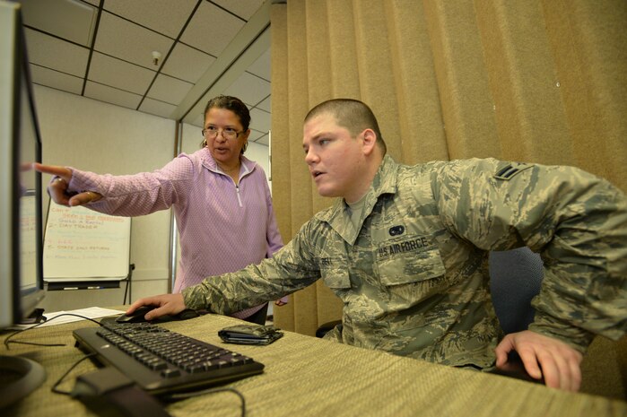 Tax center site coordinator Angie Barber assists Airman 1st Class Aaron Bell in retrieving forms necessary to file his tax return Jan. 29 at Hill Air Force Base, Utah. The base tax center is located in the Poe Conference Center, building 1295. (U.S. Air Force photo by R. Nial Bradshaw)