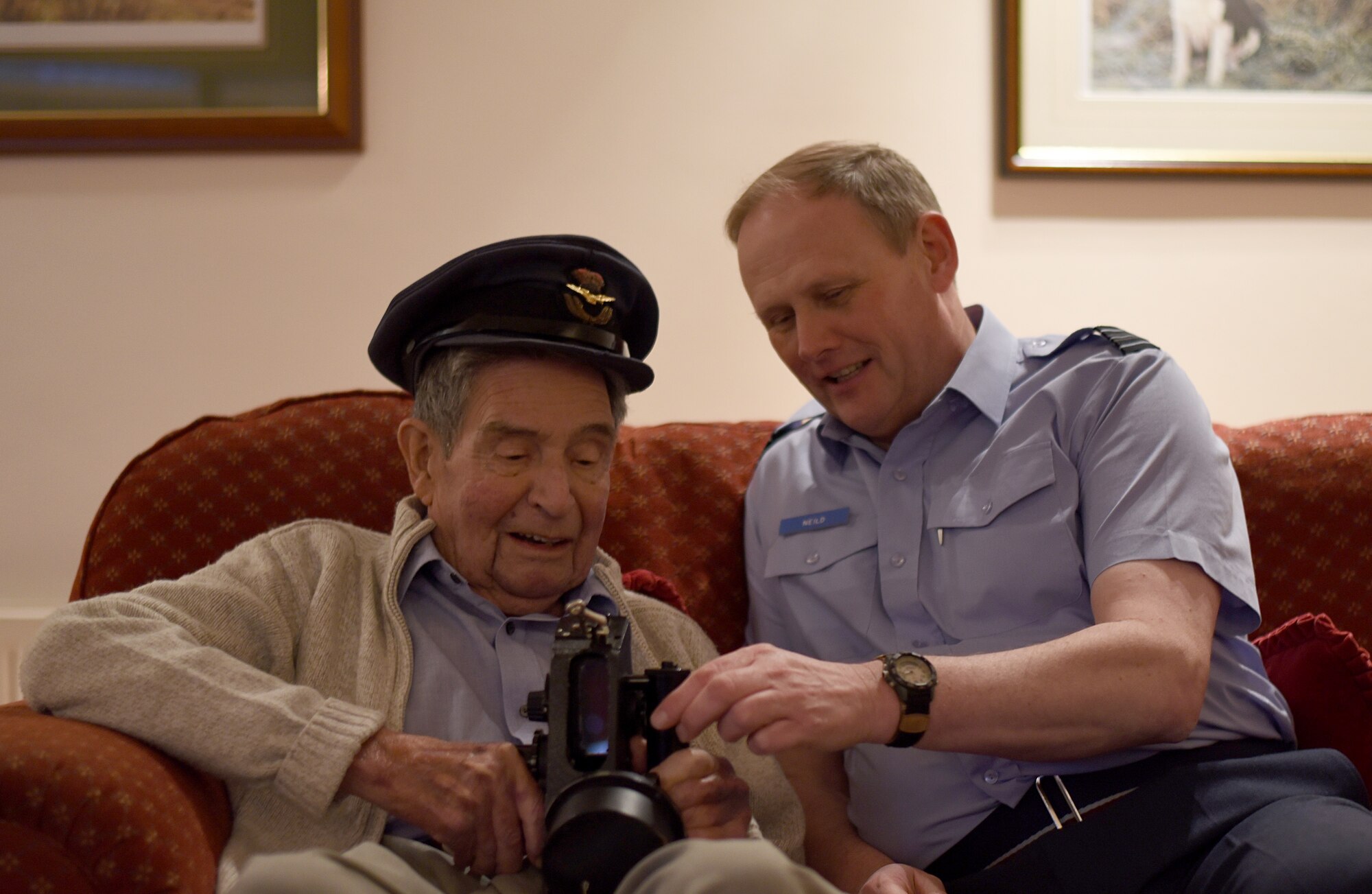 Roy Smith, a Royal Air Force Stirling bomber navigator during World War II, interacts with RAF Squadron Leader Jerry Neild, during a visit to RAF Lakenheath, England, Jan. 17, 2016. Smith and his family visited various landmarks on the base that may have been recognizable to him from his time stationed at RAF Lakenheath in 1943. (U.S. Air Force photo/Senior Airman Erin Trower) 