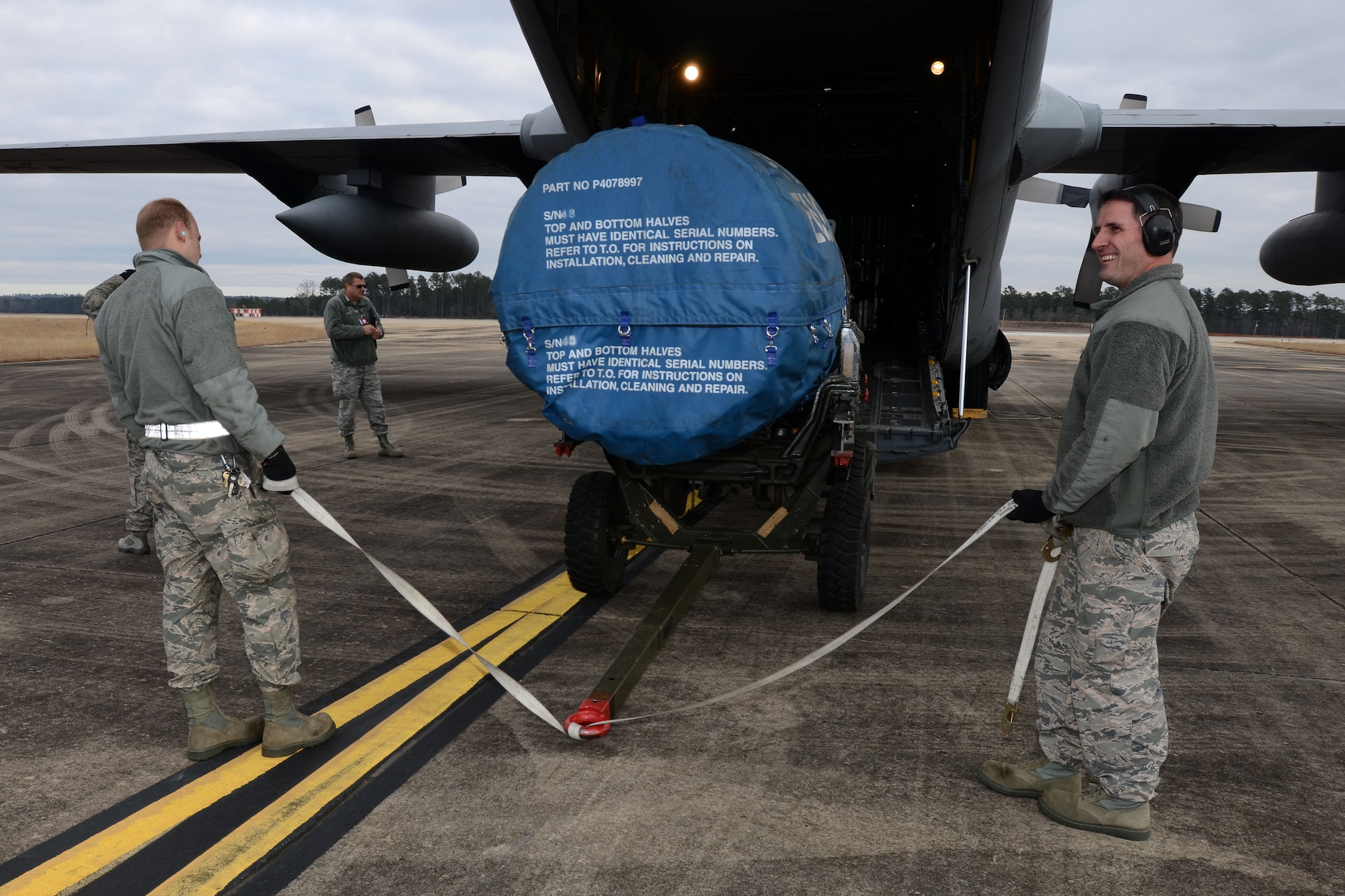 U.S. Air Force Staff Sgt. Steve Rutherford, a vehicle maintenance technician, left, and Tech. Sgt. Bennett Koenig, a logistics manager, both assigned to the 169th Logistics Readiness Squadron load an F-16 Fighting Falcon engine onto a C-130H3 Hercules cargo plane at McEntire Joint National Guard Base, S.C., Jan. 21, 2016. The cargo will be transported to Nellis Air Force Base, Nev., to be used in an upcoming training deployment for the South Carolina Air National Guard.  (U.S. Air National Guard photo by Airman 1st Class Megan Floyd)