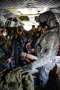 U.S. Army Sgt. Jesse Gomez, 1-228th Aviation Regiment crew chief helps Honduran troops load a U.S. Army CH-47 Chinook helicopter in the Gracias a Dios Department (state), Honduras, Jan. 13, 2016. The troops were transported in support of Operation CARAVANA, a mission to reach austere locations department and degrade the trafficking of illicit materials there. (U.S. Air Force photo by Senior Airman Westin Warburton/Released)