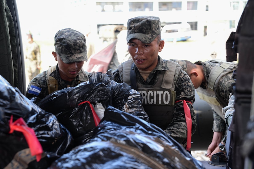 Two Honduran soldiers load cargo onto a U.S. Army UH-60 Blackhawk helicopter at Gracias a Dios Department (state), Honduras, Jan. 13, 2016. The troops received transport to various locations in the department to help with the disruption of drug trafficking in the region. (U.S. Air Force photo by Senior Airman Westin Warburton/Released)