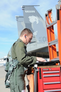 U.S. Air Force Capt. Alexander Frank, F-15 student pilot, reviews the forms prior to a check ride in the F-15 Eagle Jan. 27, 2016 at Kingsley Field in Klamath Falls, Ore.  During this flight, Frank had to demonstrate his ability to fly in inclement weather using the aircraft instruments.  (U.S. Air National Guard photo by Tech. Sgt. Jefferson Thompson/released)