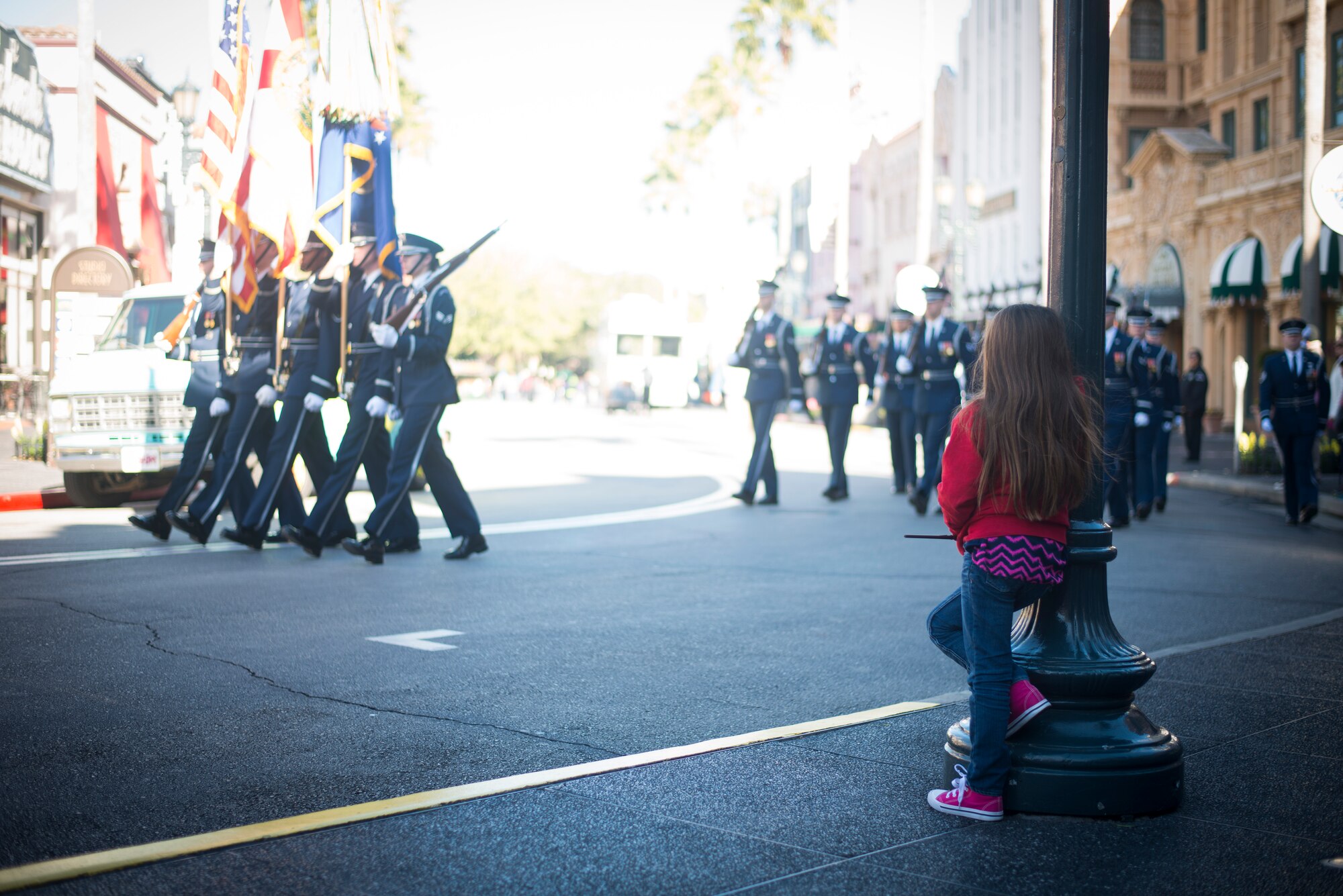 A young child looks on as members of the United States Air Force Honor Guard march during a performance at Universal Studios in Orlando, Fla. Jan. 20, 2016. After marching through the park, the Honor Guard finished with a performance by the drill team. (U.S. Air Force photo by Staff Sgt. Chad C. Strohmeyer/Released)