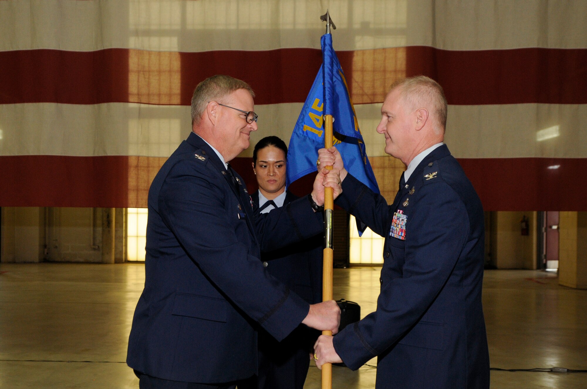 U.S. Air Force Col. Marshall C. Collins, commander, 145th Airlift Wing, passes the unit guidon to Col. Allan R. Cecil signifying his assumption of command of the 145th Maintenance Group during a Change of Command ceremony held at the North Carolina Air National Guard Base, Charlotte Douglas International Airport, Jan. 9, 2016. Cecil is the first non-flying maintenance officer to hold the position of commander of the 145th Maintenance Group in the history of the North Carolina Air National Guard. (U.S. Air National Guard photo by Staff Sgt. Julianne M. Showalter /Released)