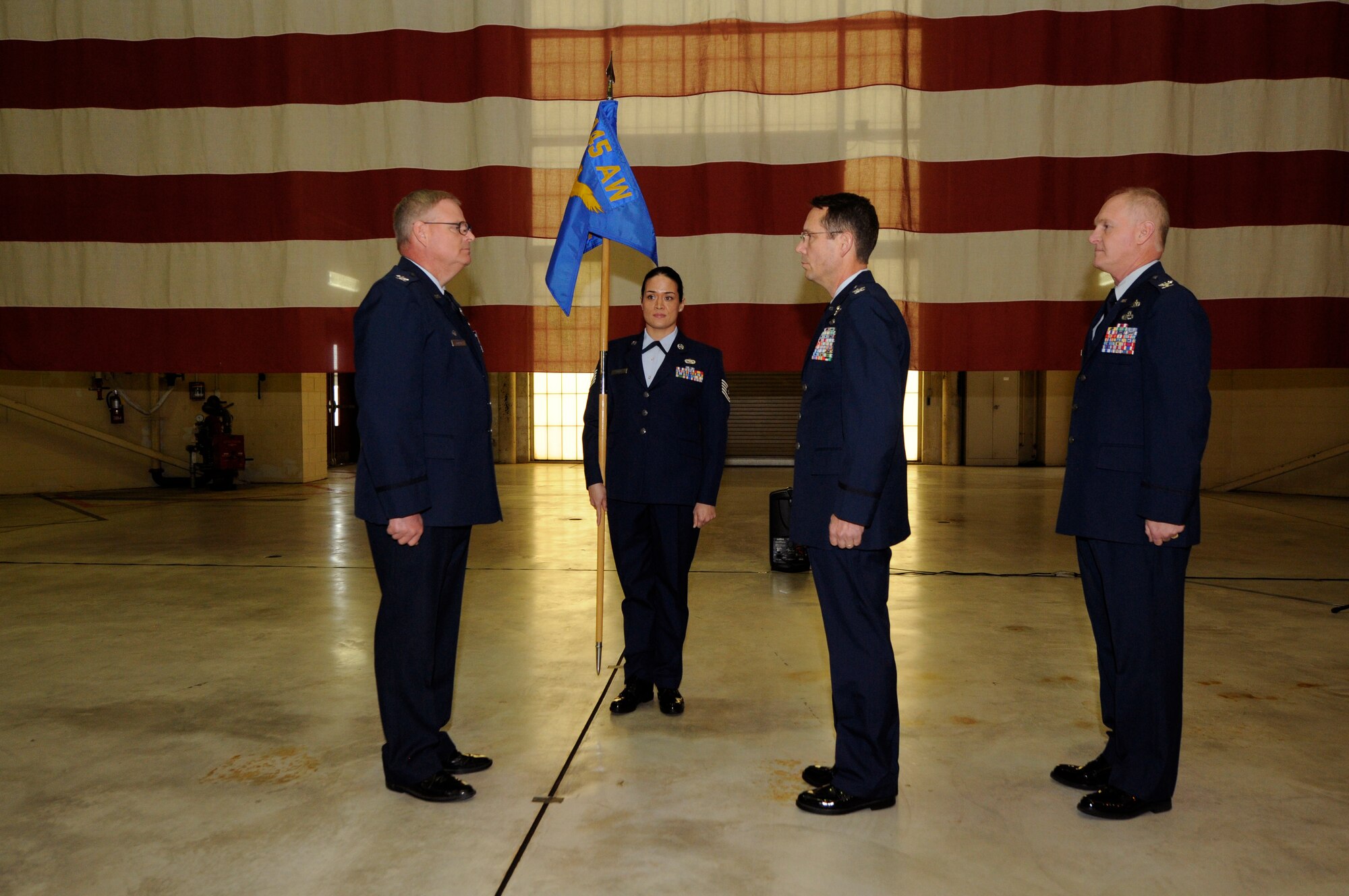 U.S. Air Force Col. Marshall C. Collins (left), commander, 145th Airlift Wing, Col. Stephen Mallette (center), commander, 145th Maintenance Group (MXG), and Col. Allan R. Cecil (right), deputy commander, 145th MXG, stand at attention during the MXG Change of Command as Mallette relinquishes command to Cecil during a ceremony held at the North Carolina Air National Guard Base, Charlotte Douglas International Airport, Jan. 9, 2016. Cecil is the first non-flying maintenance officer to hold the command position of the 145th Maintenance Group in the history of the North Carolina Air National Guard. (U.S. Air National Guard photo by Staff Sgt. Julianne M. Showalter /Released)