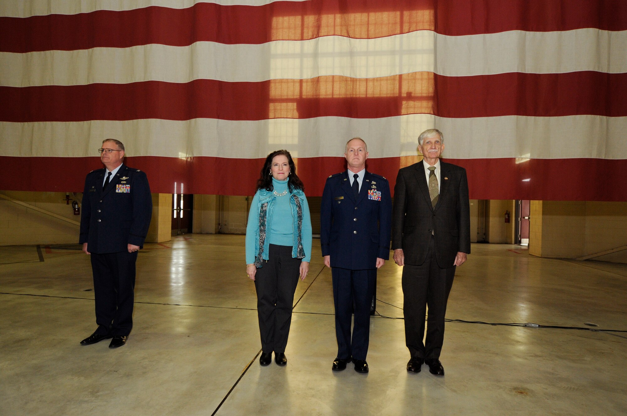 U.S. Air Force Lt. Col. Allan R. Cecil (center), deputy commander of the 145th Maintenance Group, his spouse, and retired Brig. Gen. Fisk Outwater, stand at attention during the reading of the promotion orders during a ceremony held in his honor at the North Carolina Air National Guard Base, Charlotte Douglas International Airport, Jan. 9, 2016. (U.S. Air National Guard photo by Staff Sgt. Julianne M. Showalter /Released)