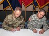Brig. Gen. Paul Bontrager, 10th Mountain Division (LI),  Fort Drum acting senior commander, and Maj. Gen. Harry Miller Jr., 42nd Infantry Division commander, along with other representatives from the Reserve and National Guard units in the Northeast and beyond, established an agreement that encourages the Army Total Force integration during the charter signing Jan. 22, 2016 at Fort Drum. Leaders representing 10 states and 17 units signed an agreement to partner with 10th Mountain Division units for future training and collaboration. (Photo by U.S. Army Master Sgt. Kap Kim)
