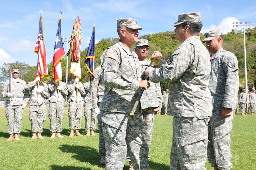 Command Sgt. Maj. Rene A. Berlingieri relinquishes responsibility to Command Sgt. Maj. Jose E. Nieves during the 166th Regional Support Group Change of Responsibility Ceremony, January 31 at the Maxi Williams Field, Fort Buchanan, Puerto Rico. Col. Mike Caraballo presents the noncommissioned officer sword to Command Sgt. Maj. Jose E. Nieves.