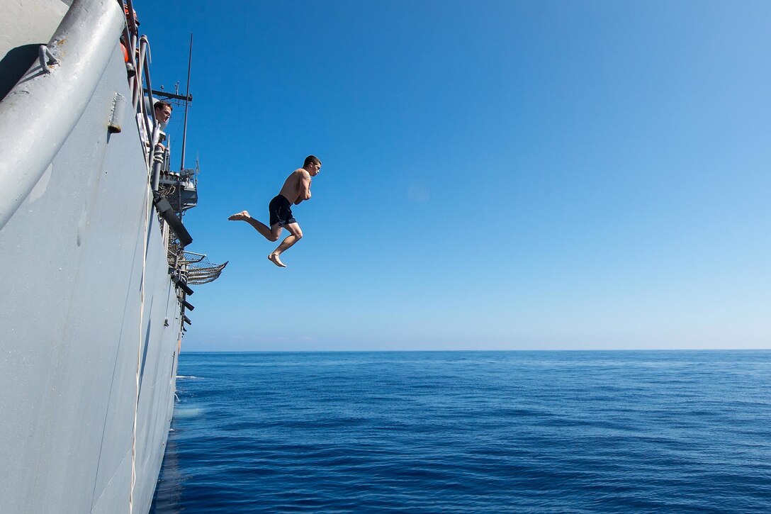 Petty Officer 3rd Class Zachary Thompson jumps during a command swim call aboard the USS Mobile Bay in the Pacific Ocean, Jan. 26, 2016. The guided-missile cruiser, assigned to the USS John C Stennis Carrier Strike Group, is deployed to the Western Pacific. Navy photo by Petty Officer 2nd Class Ryan J. Batchelder