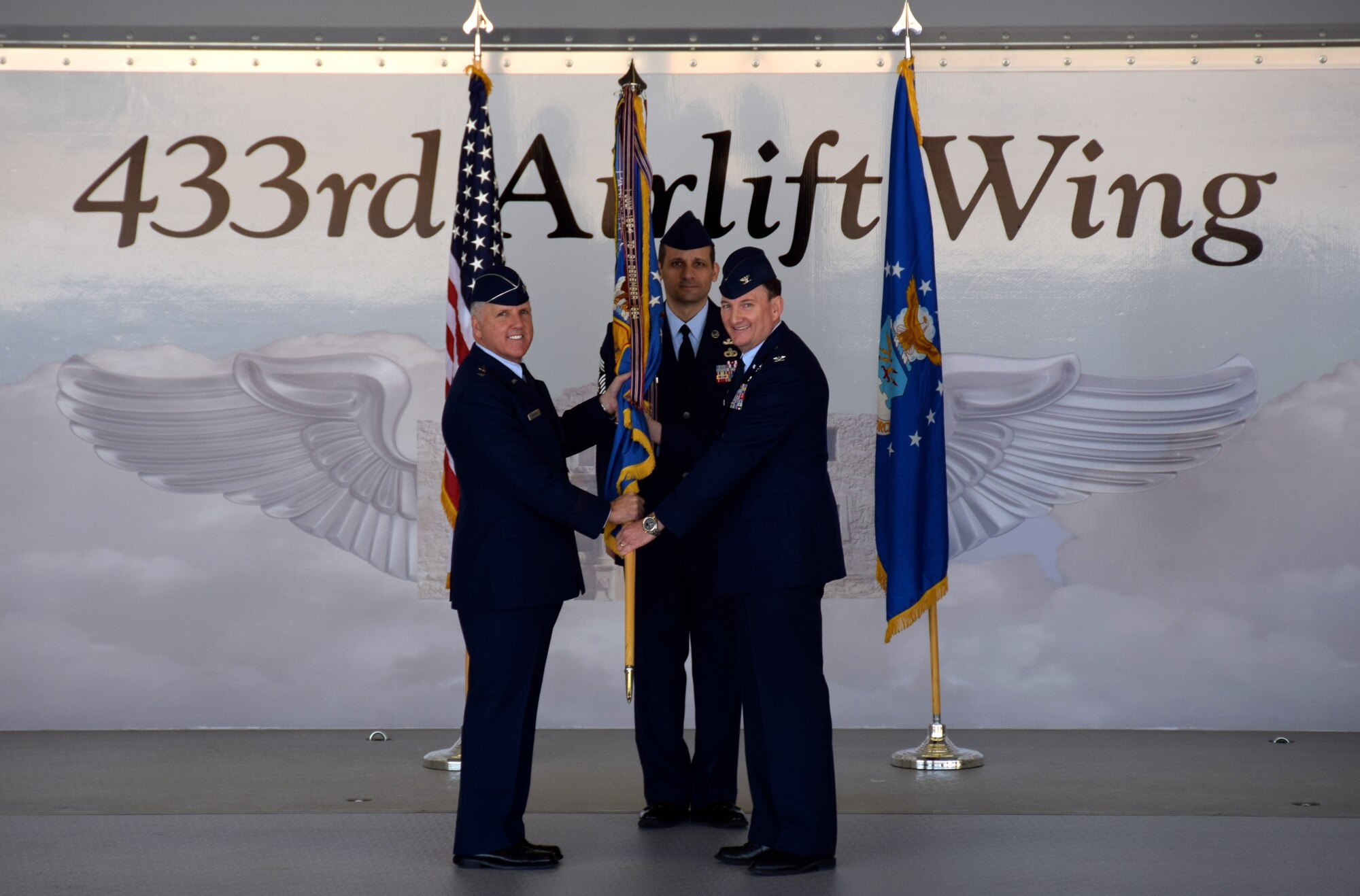 Maj. Gen. John C. Flournoy, Jr., 4th Air Force commander, passes the 433rd Airlift Wing guidon to Col. Thomas T.K. Smith, Jr., who assumes command of the wing during an assumption of command ceremony Jan. 30, 2016. Throughout his career, Smith serviced with the 433rd AW in numerous roles from 2001 to 2012 before becoming the 507th Operations Group commander at Tinker Air Force Base, Oklahoma. His last assignment prior to joining the Wing was at the 459th Air Refueling Wing commander at Joint Base Andrews, Washington. (U.S. Air Force photo/Senior Airman Bryan Swink)