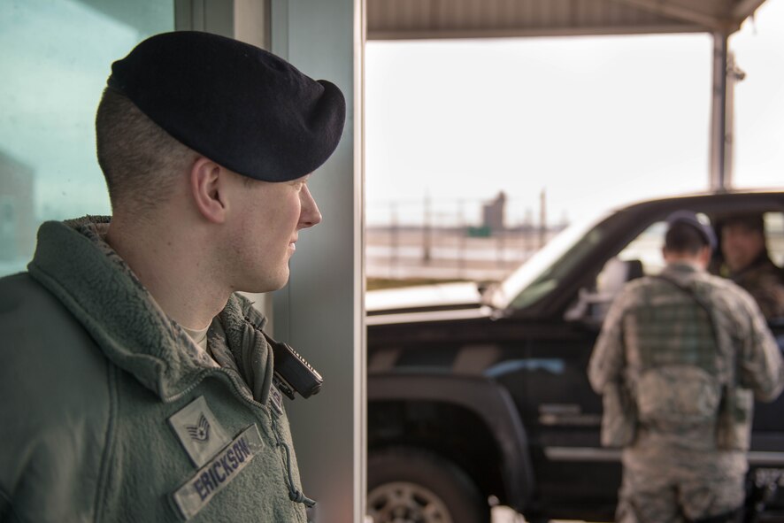 Staff Sgt. Tyler Erickson watches as Senior Airman Caleb Steeves checks an I.D. card Jan. 31 (U.S. Air Force Photo by Staff Sgt. Trevor Saylor)