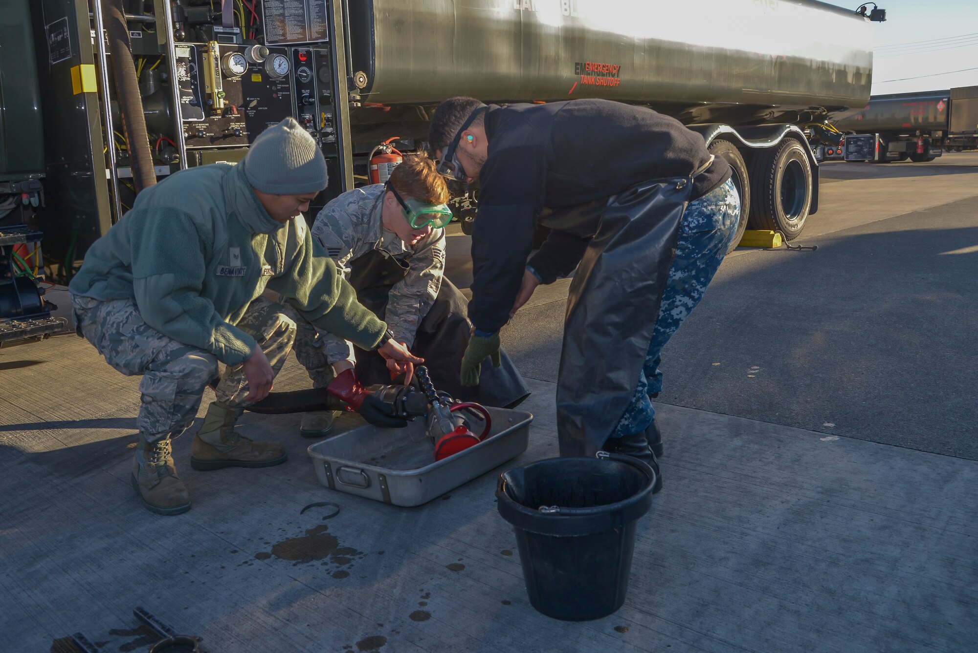 Airmen from the 374th Logistics Readiness Squadron fuels management flight instruct Petty Officer 3rd Class Deandre Jerman, Naval Air Facility Atsugi Carrier Airborne Early Warning Squadron administrative assistant, how to properly place a nozzle onto a fuel hose at Yokota Air Base, Japan, Jan. 26, 2016. Navy personnel learned how to drive R-11 refueling trucks, service aircraft with them, perform minor maintenance for the vehicle and how to check fuel samples. (U.S. Air Force photo by Senior Airman David Owsianka/Released)